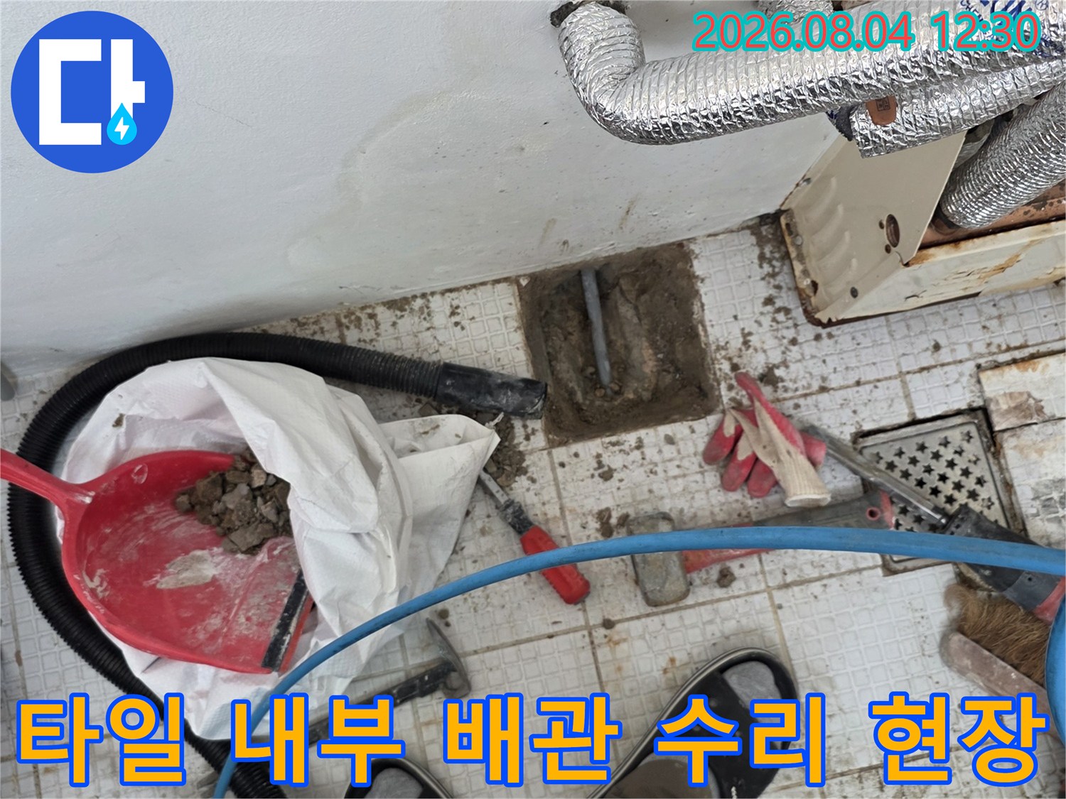 파헤쳐진 타일 벽면과 노출된 온수 배관의 점검 모습