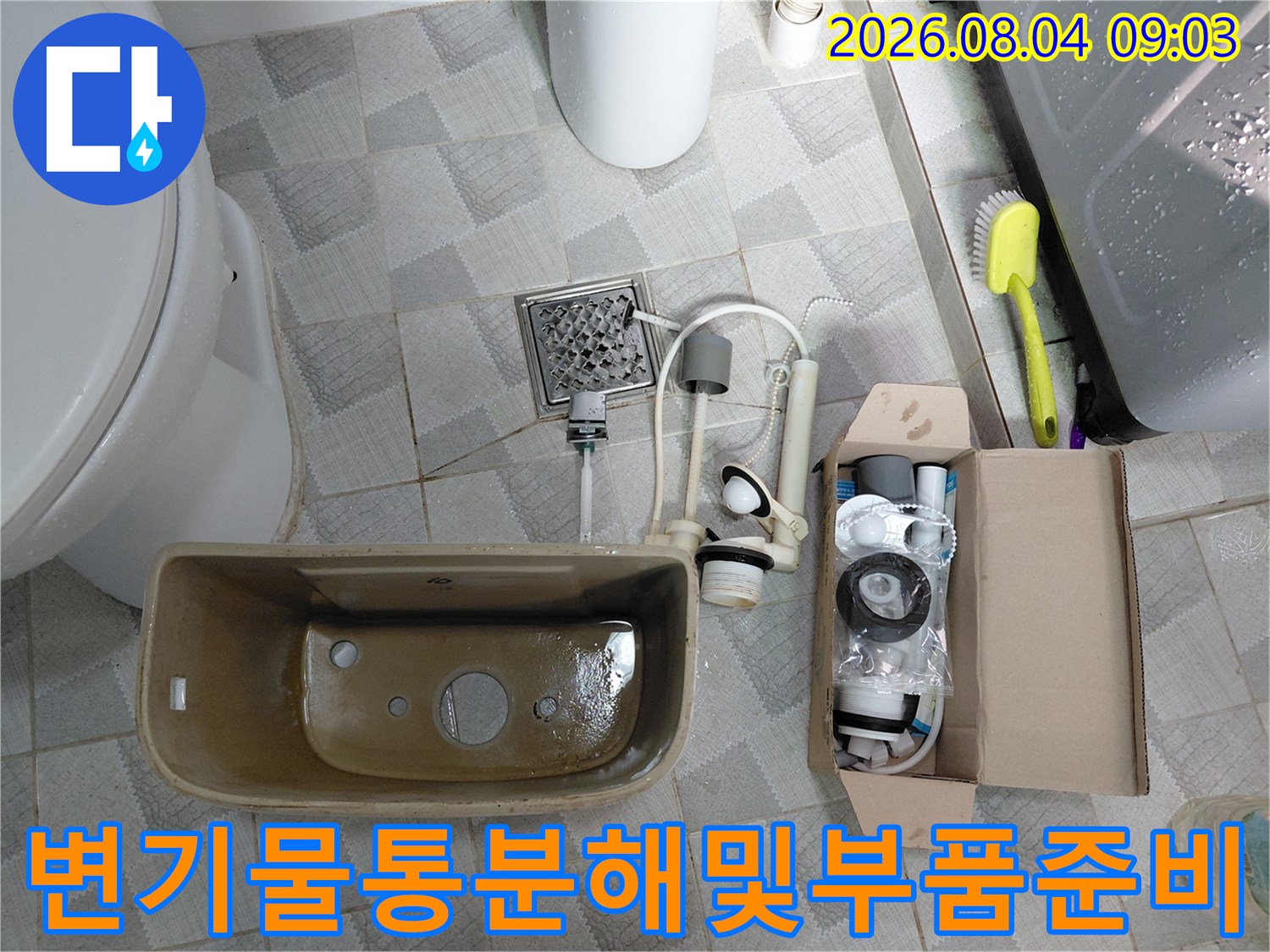변기 물통을 제거하고 새로운 부속들로 교체하기 전의 작업 준비 모습