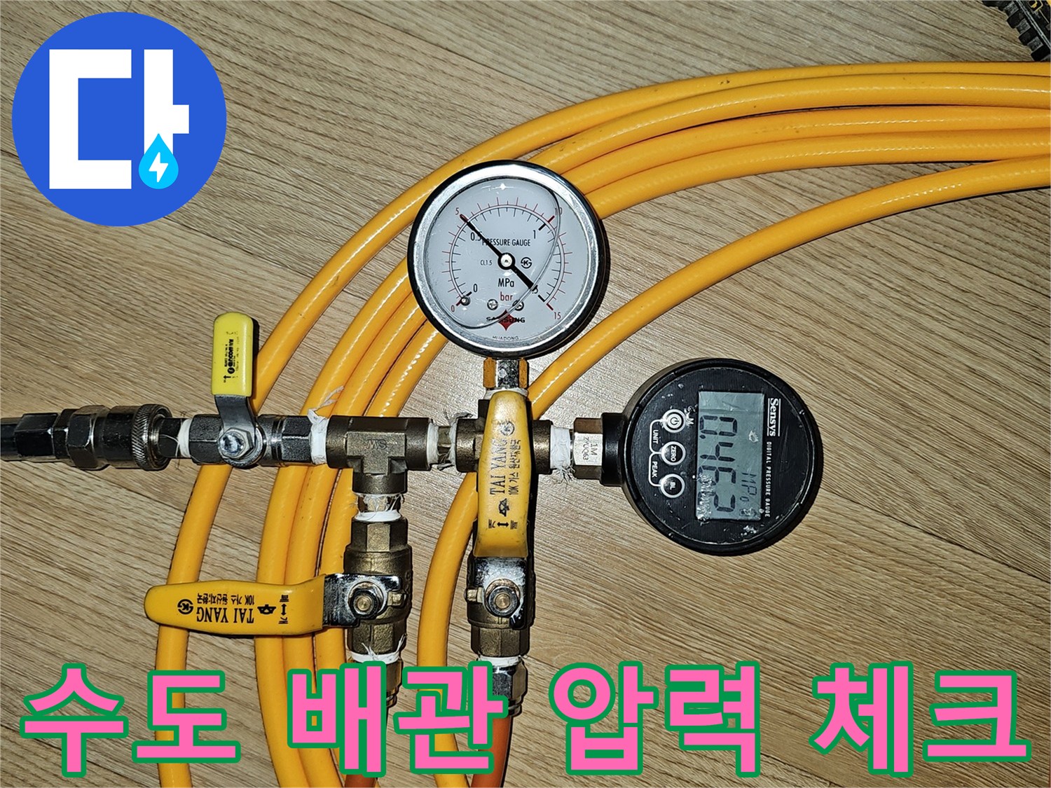 배관 연결 부위에 설치된 압력 측정 장치와 노란색 호스