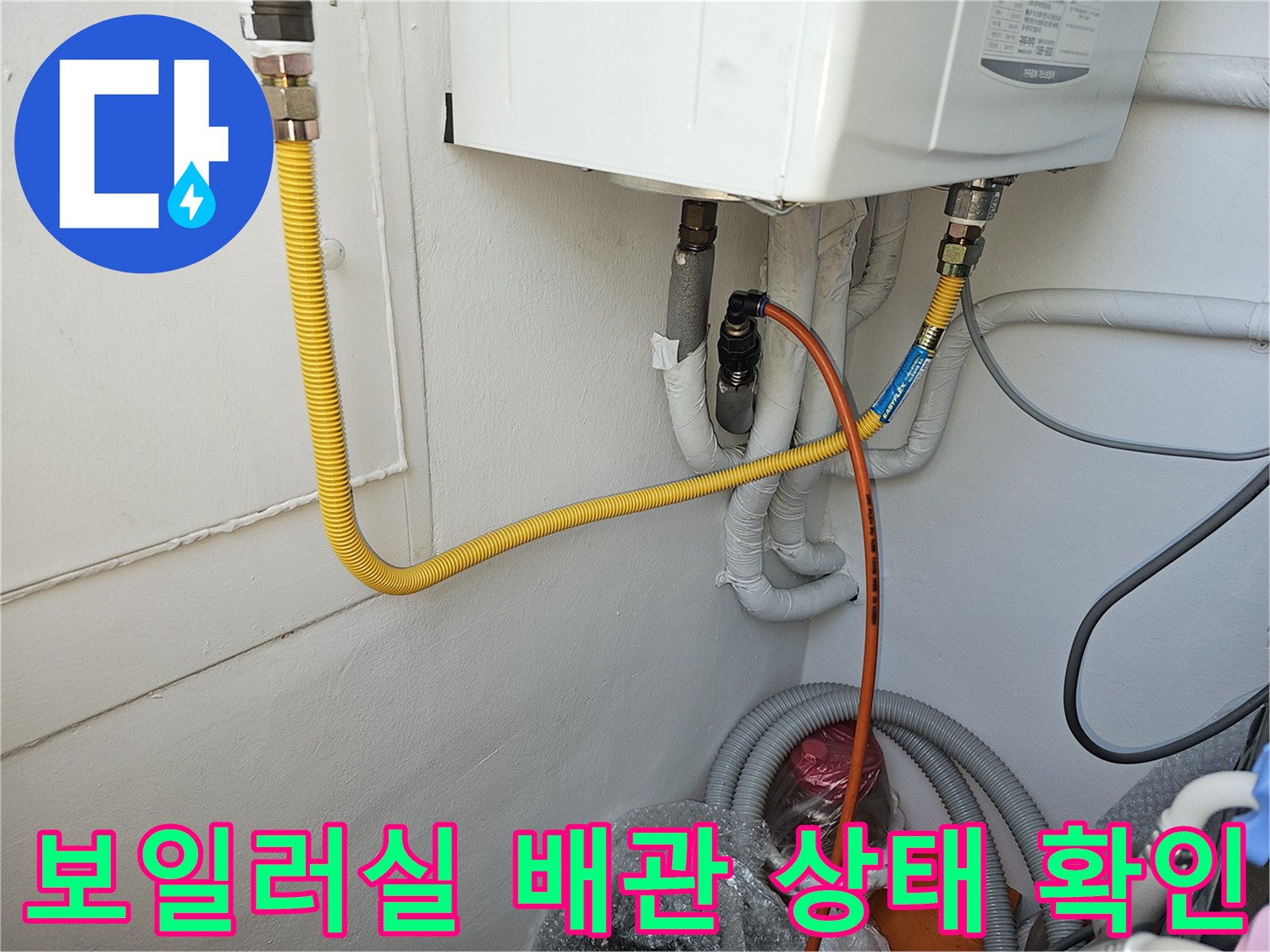 보일러 아래쪽의 여러 가지 배관과 호스 연결 모습