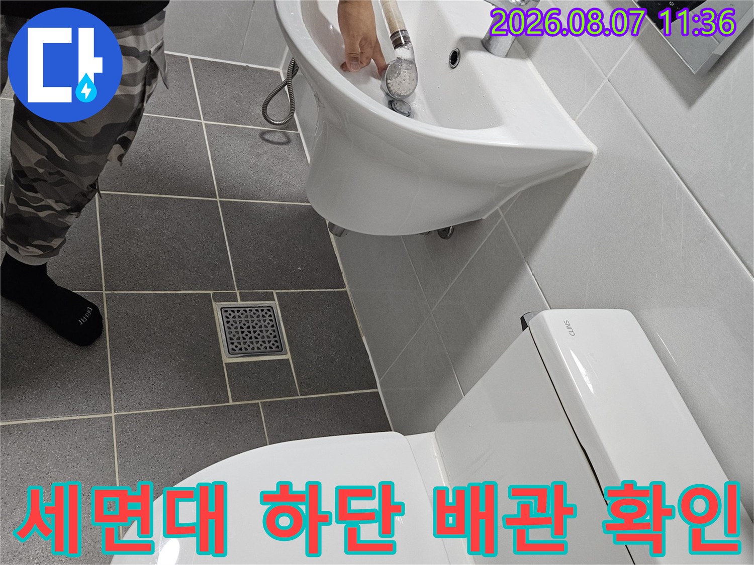 세면대 수전과 변기 사이의 배관 연결 부위를 면밀히 관찰하고 있습니다.