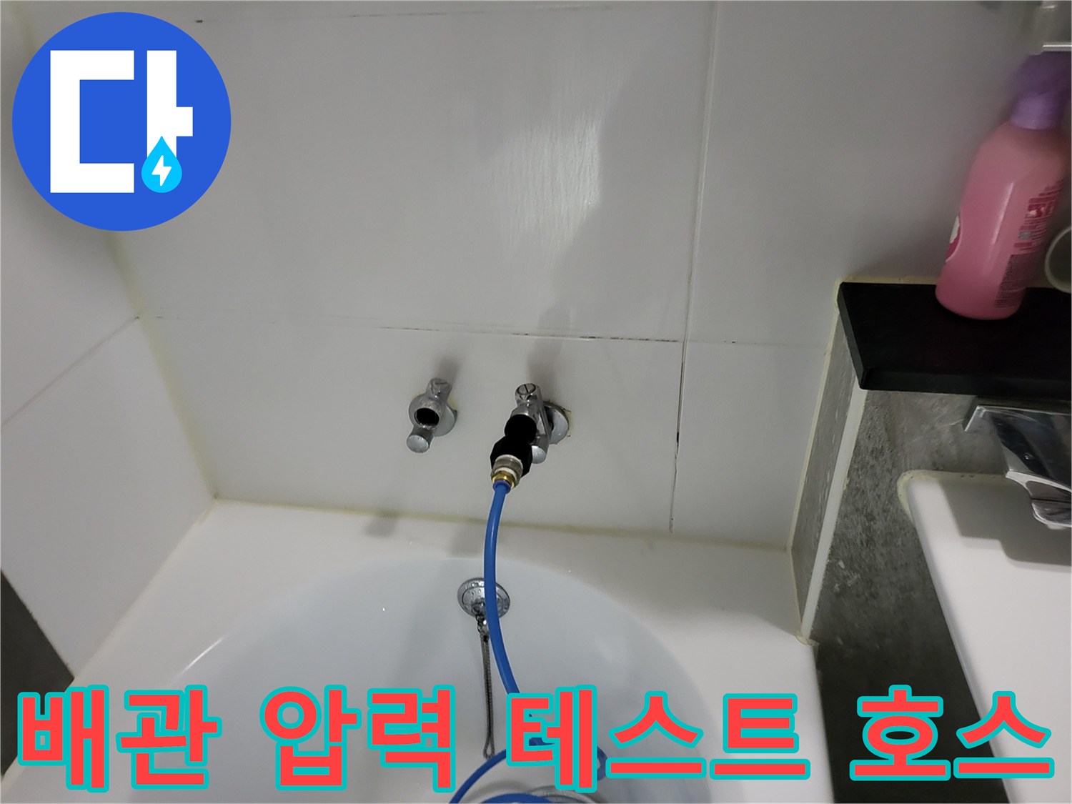 욕실 벽체 배관에 연결된 파란색 공압 테스트용 호스 상세 사진