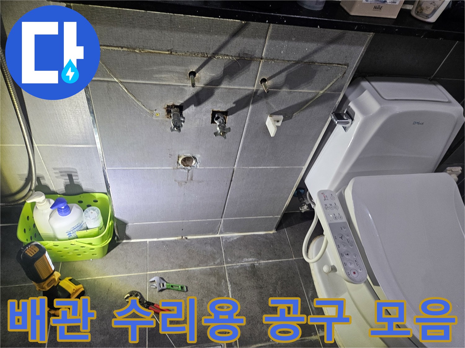 공사가 진행 중인 화장실 바닥의 렌치와 전동 드릴 장비