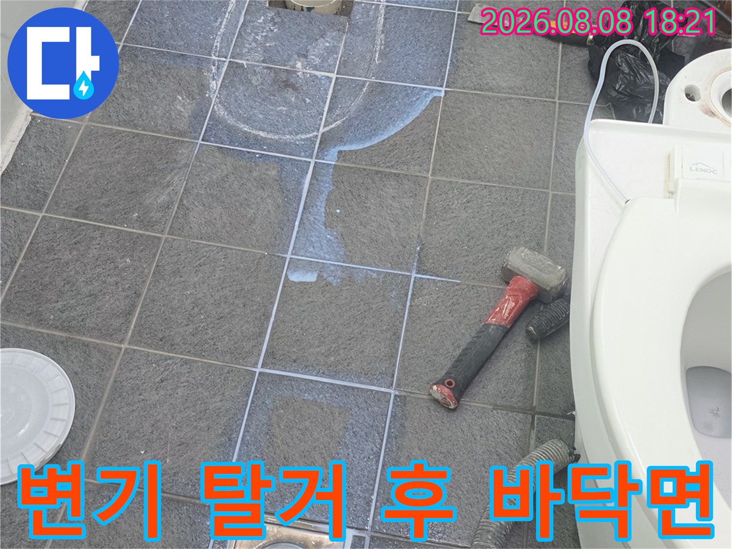 변기를 제거하고 드러난 젖은 타일과 배수구 주변 상황