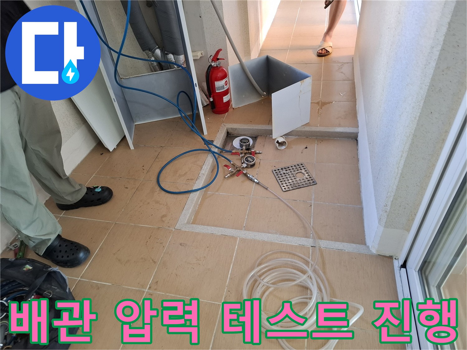 싱크대 밑 바닥 배관에 연결된 공압식 점검용 호스와 장비