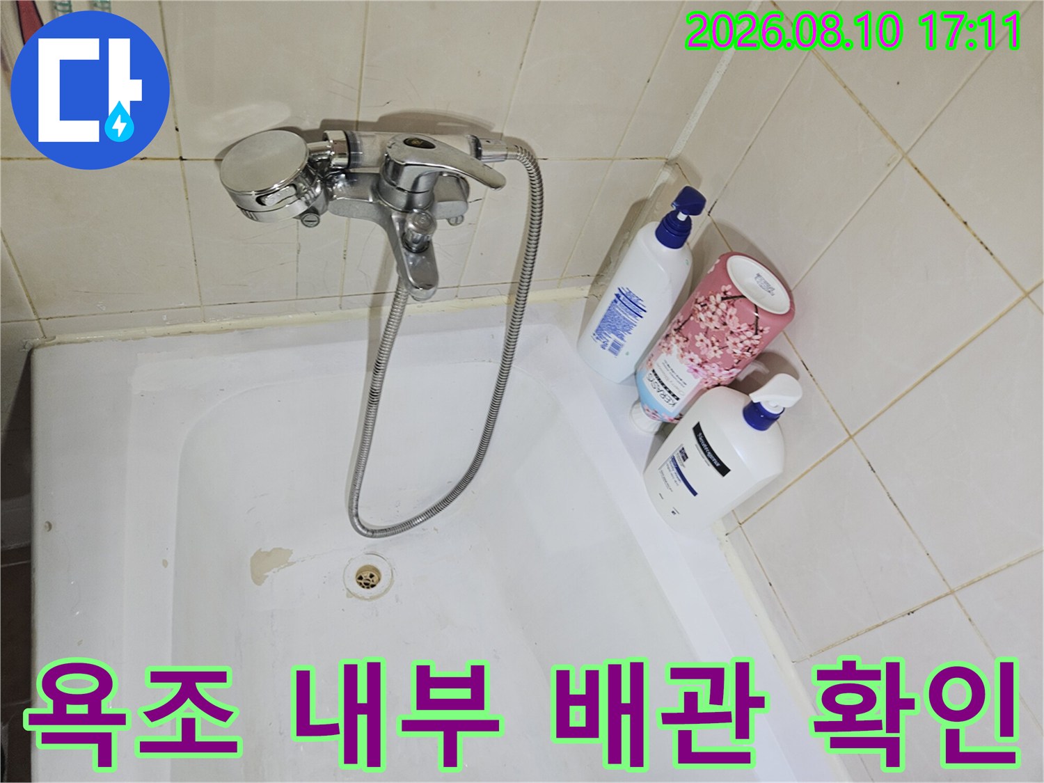 욕조 안쪽의 수전과 샤워기 호스 연결 상태를 보여주는 사진입니다.