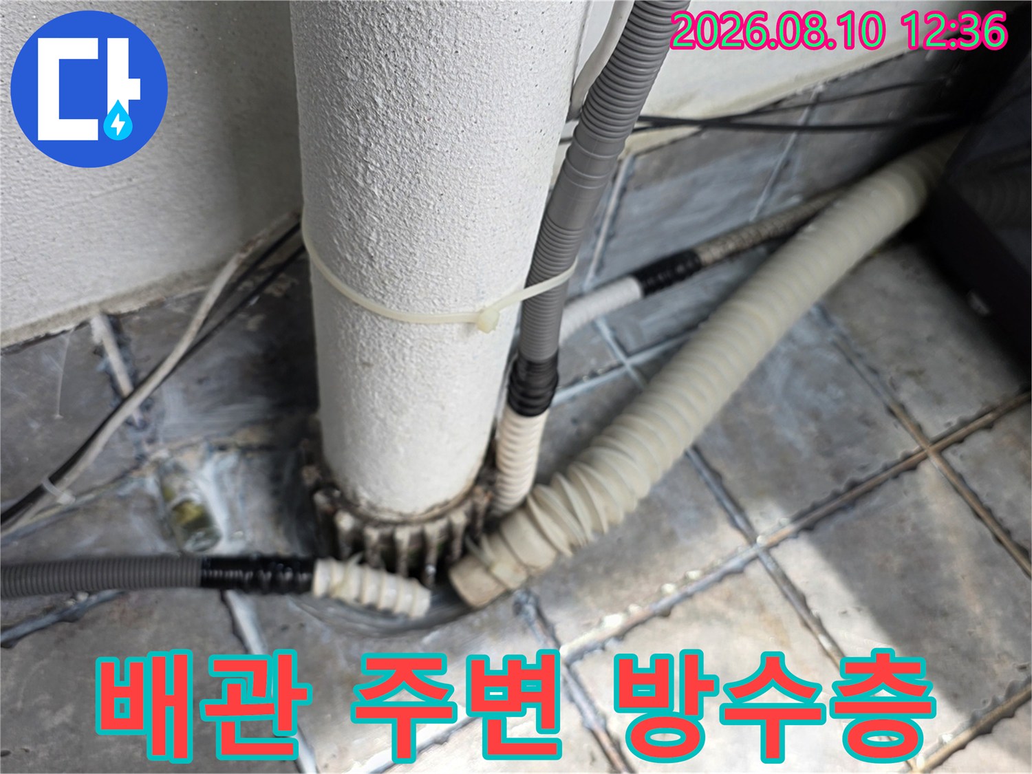 노후된 배관 연결 부위와 타일 틈새의 습기 상태를 촬영한 사진입니다