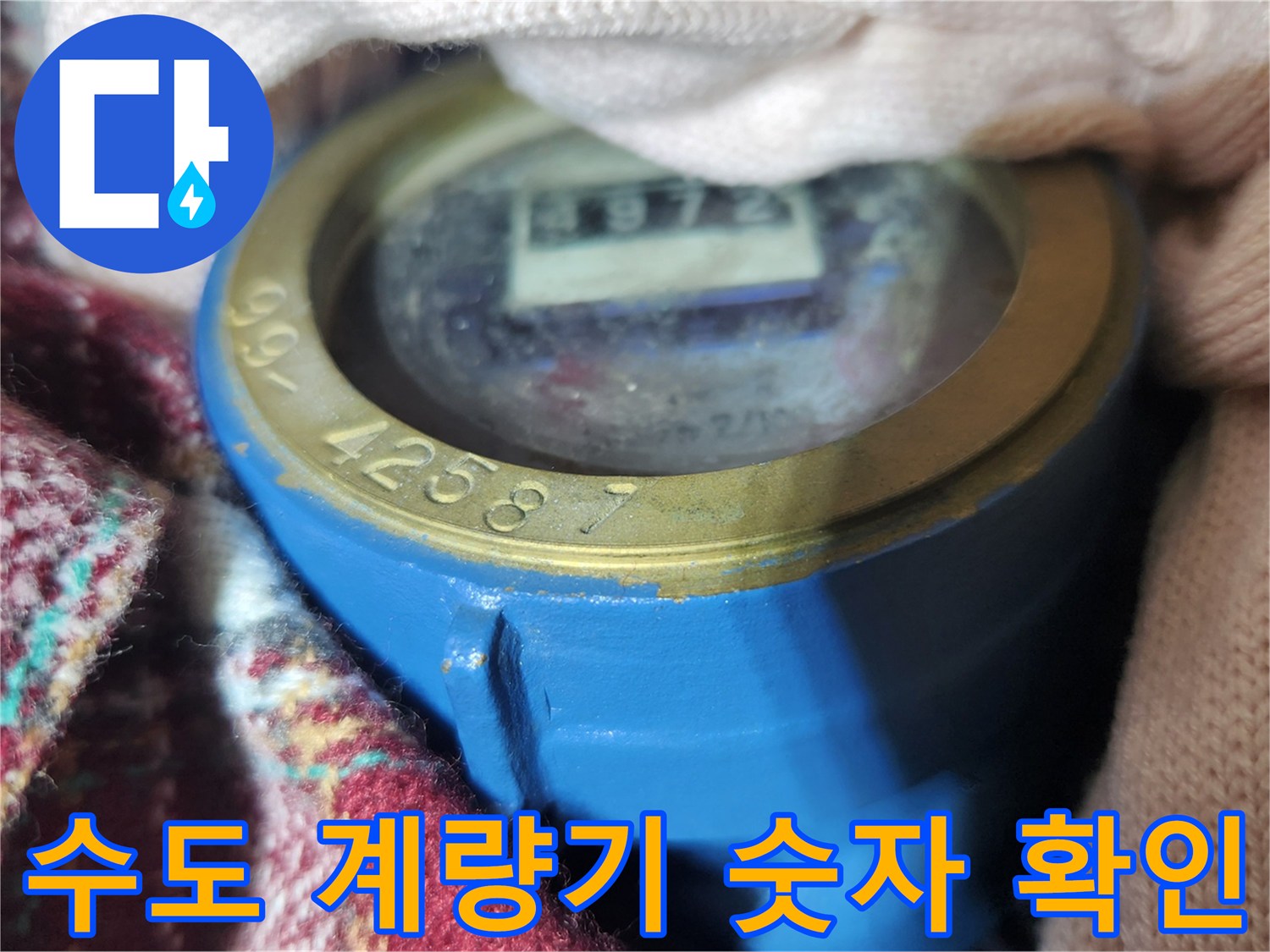 파란색 몸체의 수도 계량기 덮개 안쪽 숫자가 보이는 모습