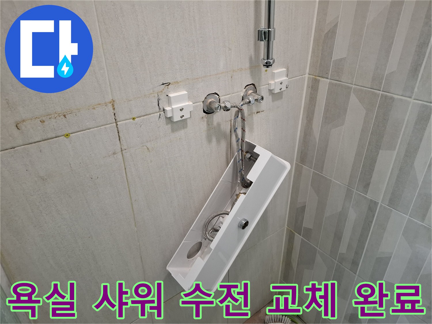 새로 설치된 샤워기 수전과 깨끗하게 마감된 욕실 타일 벽면