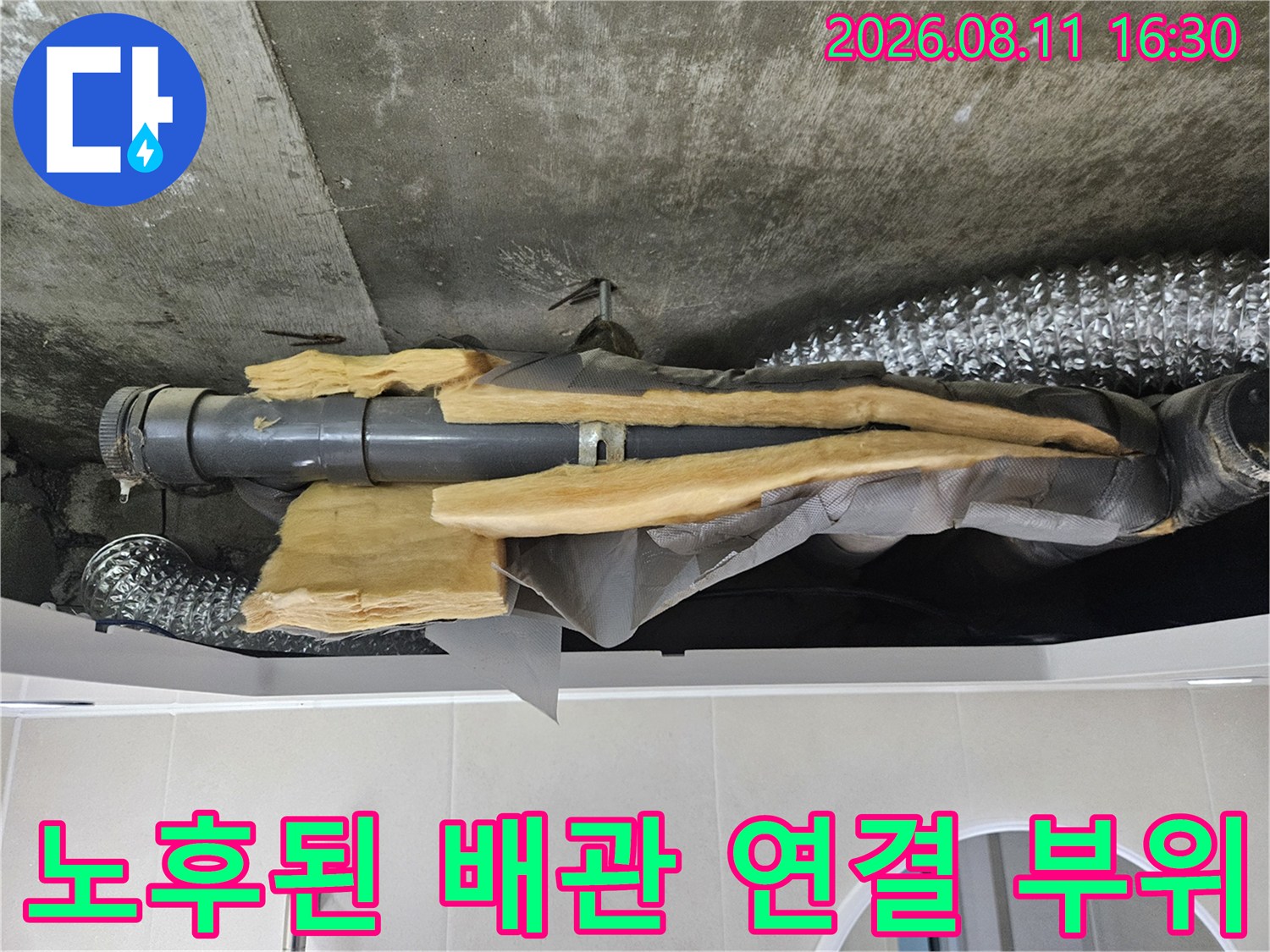 습기가 머금어진 보온재와 노후된 배관의 연결 상태를 보여주는 사진입니다.