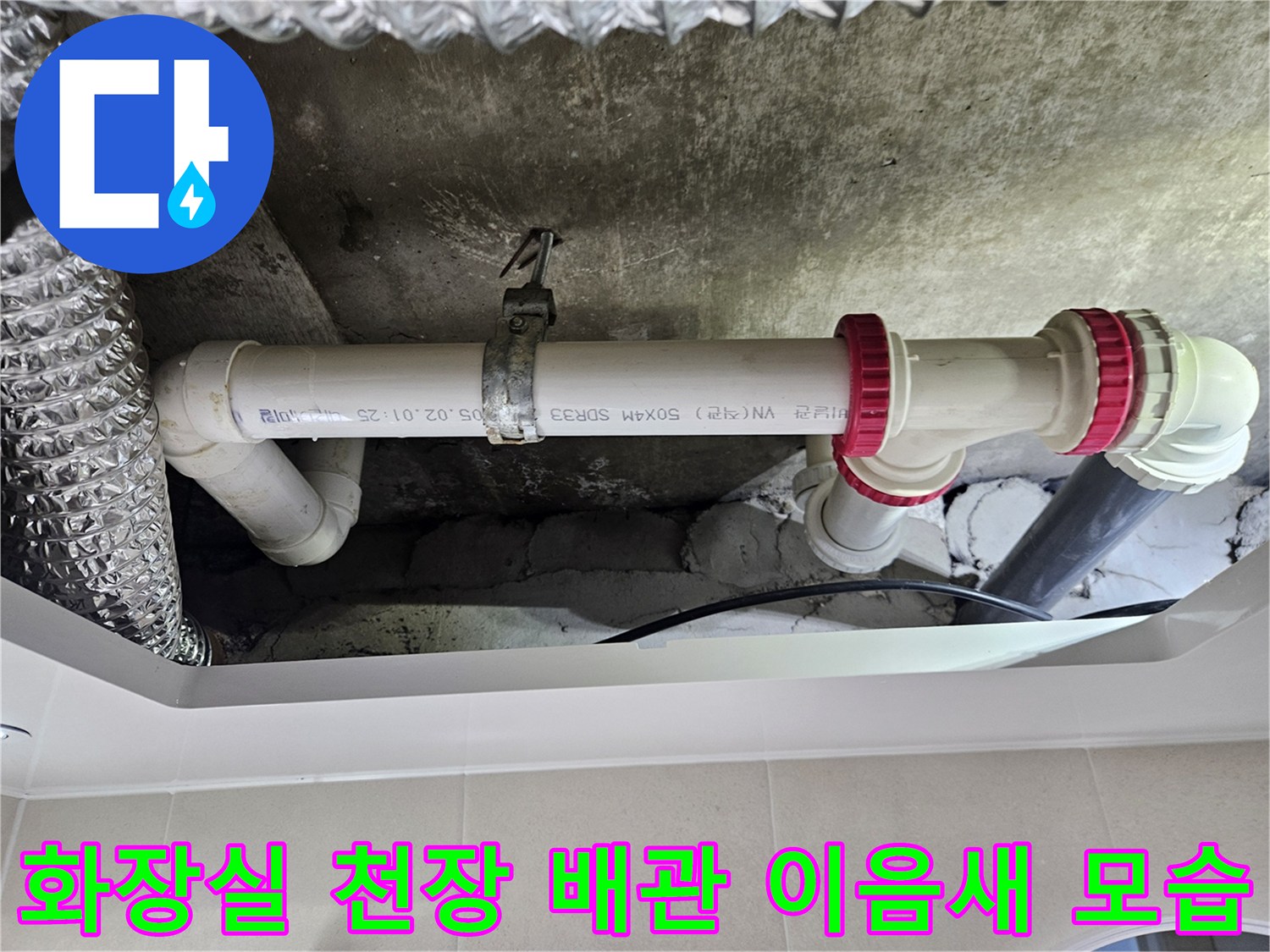 흰색-PVC-배관의-연결부와-빨간색-고무패킹이-노출된-천장-내부