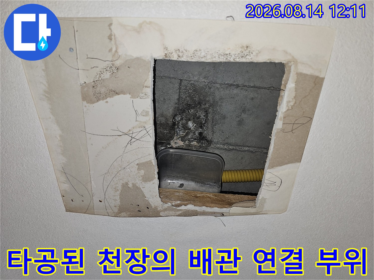 천장 타공을 통해 드러난 금속 부속과 노란색 주무관의 모습