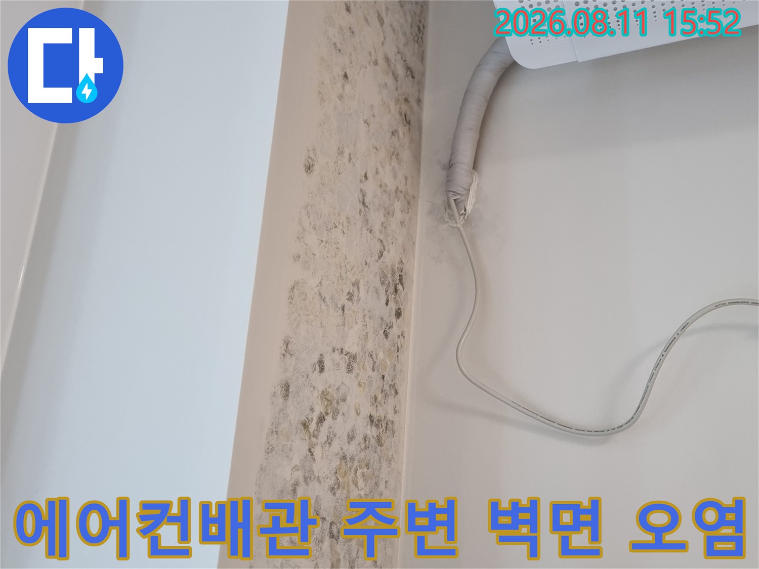 흰색 에어컨 실내기 아래쪽 벽면에 누수로 인한 갈색 얼룩과 곰팡이가 퍼져 있는 모습
