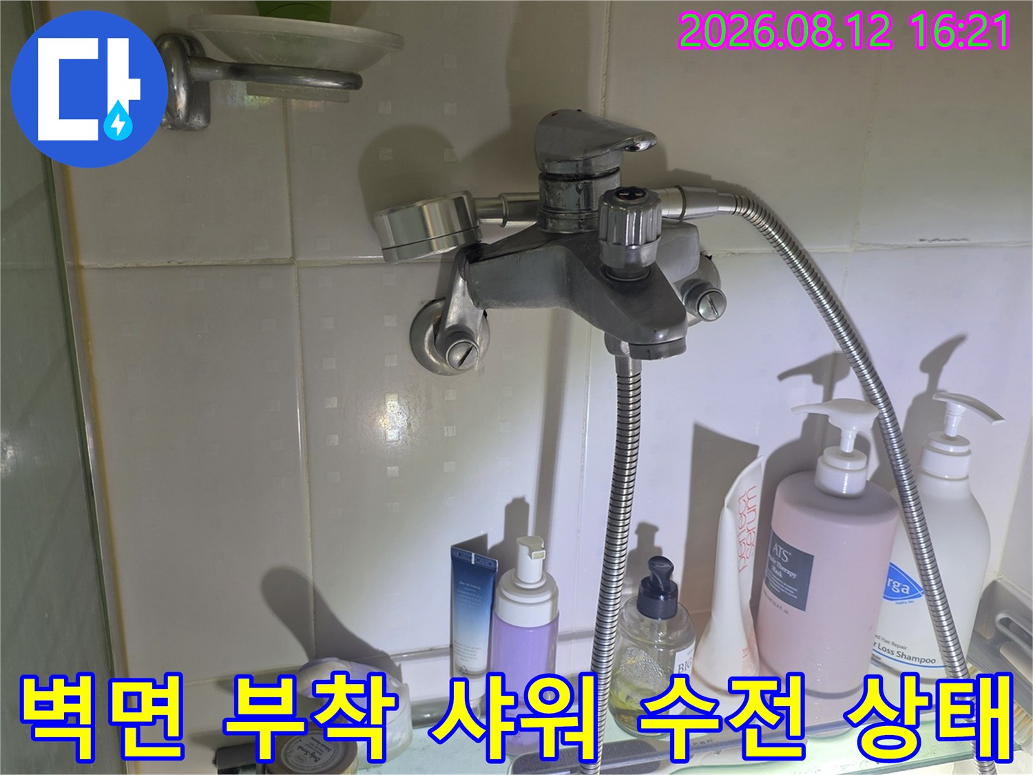 금속 소재의 욕실 샤워기 수전과 그 주변에 놓인 세면도구들-배관 점검 사진