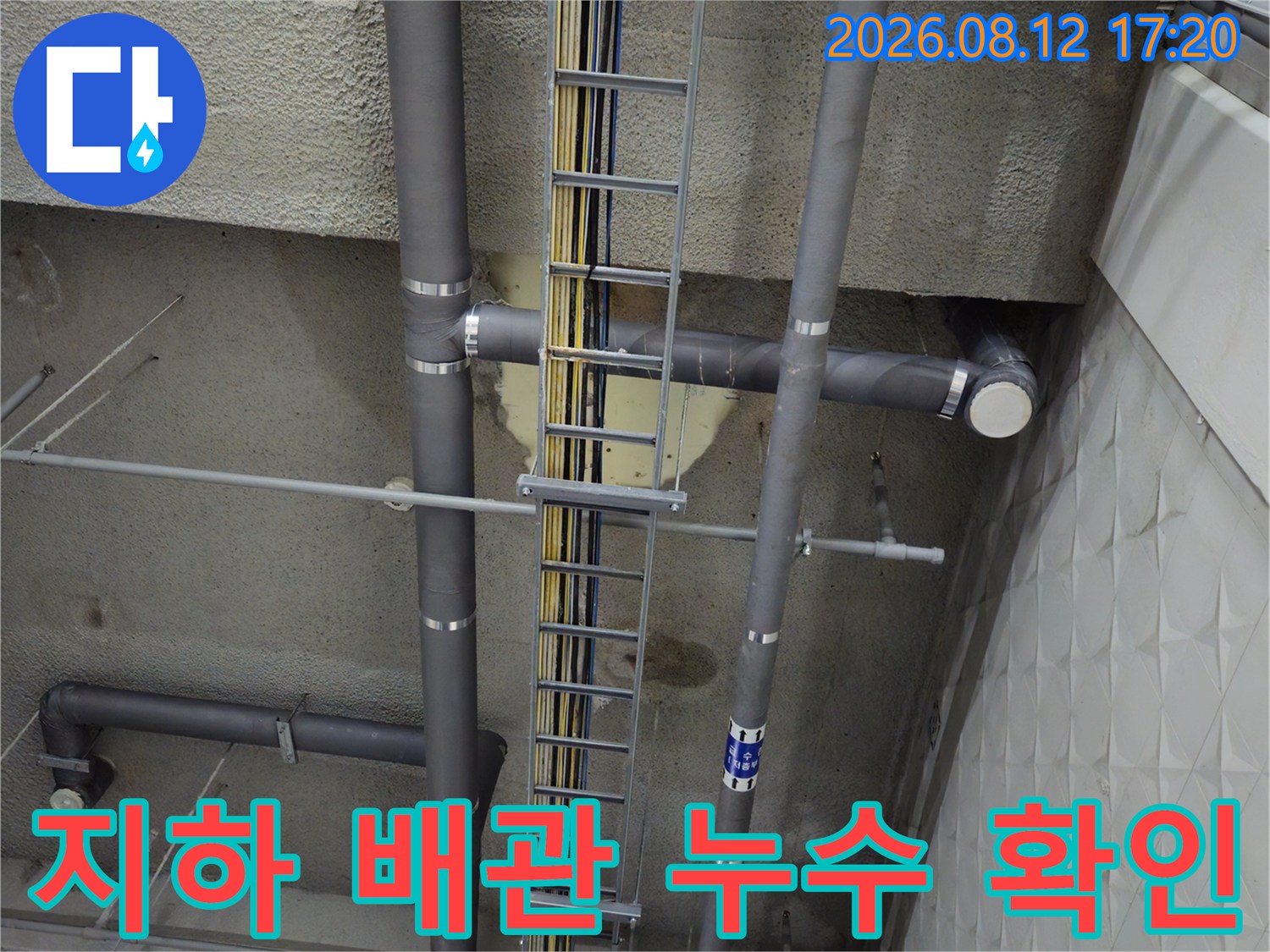 지하주차장 천장에 설치된 회색 배관과 전선용 트레이 시설입니다.