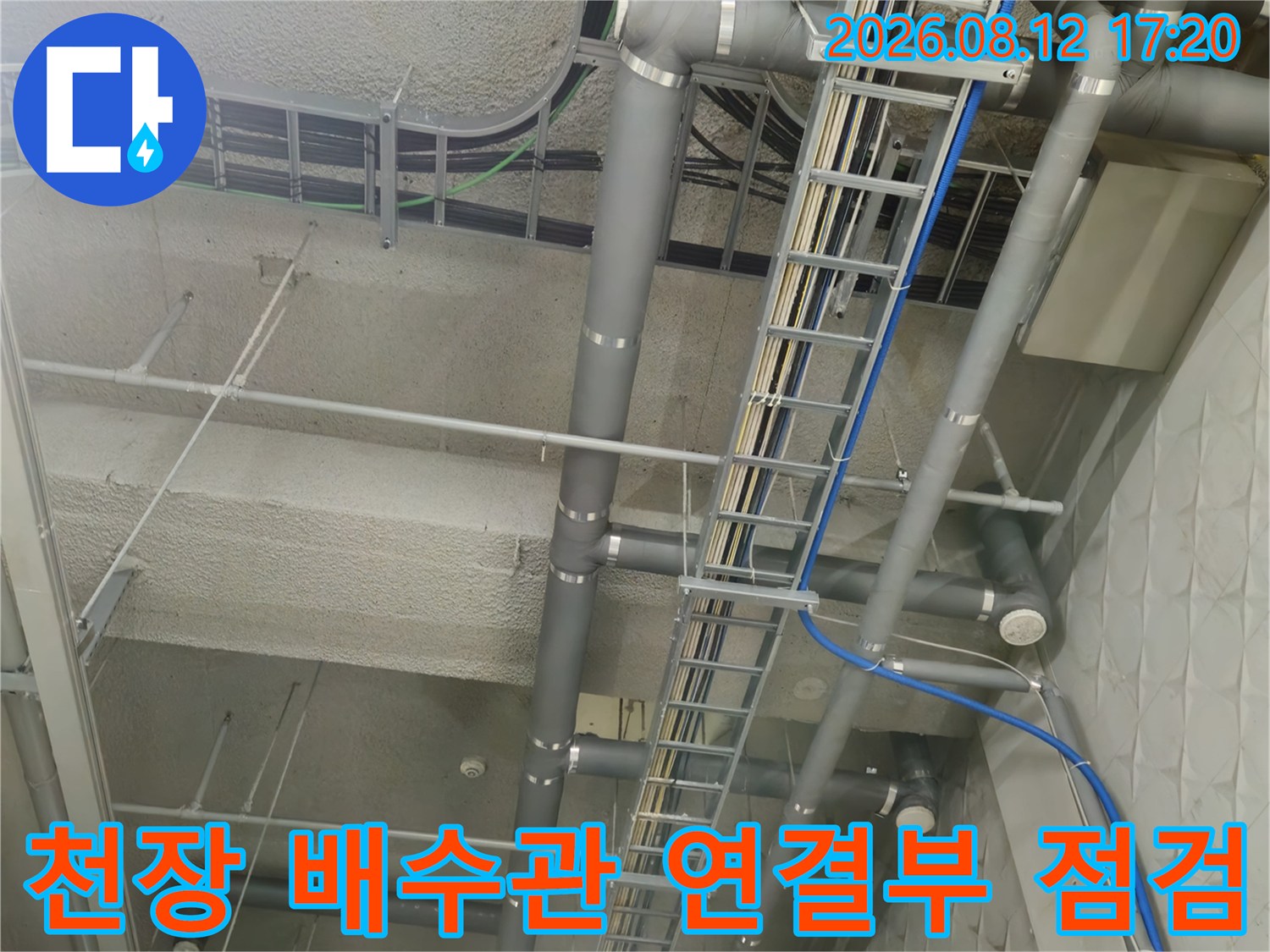 지하주차장 천장의 회색 PVC 관과 파란색 호스 및 트레이 시설