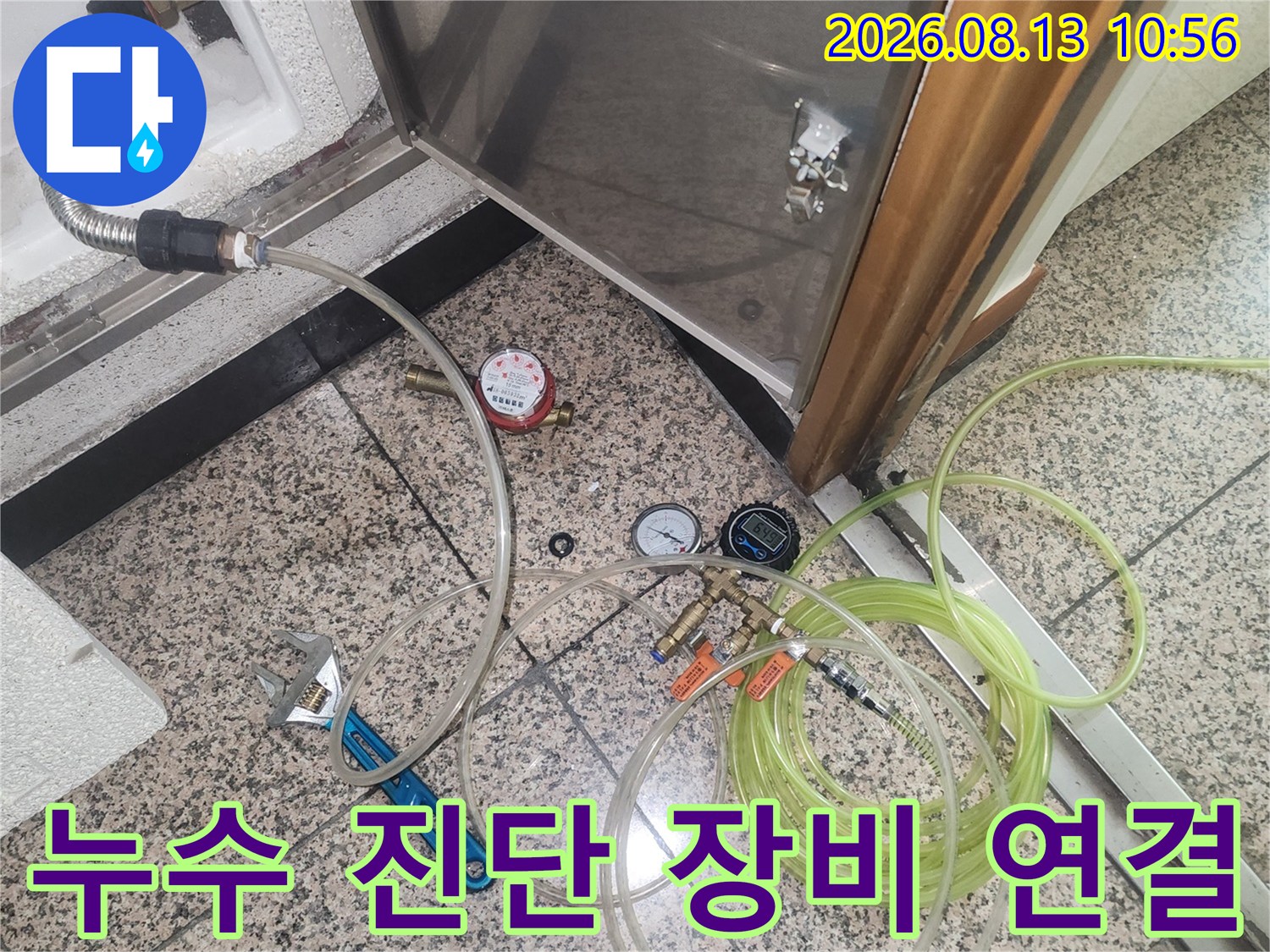 스테인리스 점검구 하부의 배관에 연결된 공압 측정 호스와 게이지-진단 현장