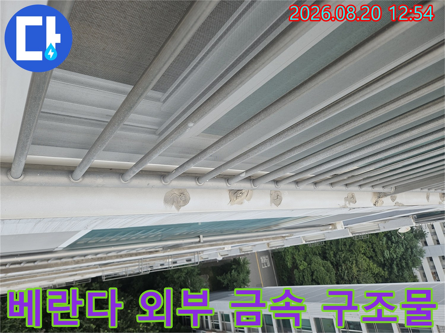 아파트 외벽에 설치된 금속 차양 프레임과 난간대 근접 사진