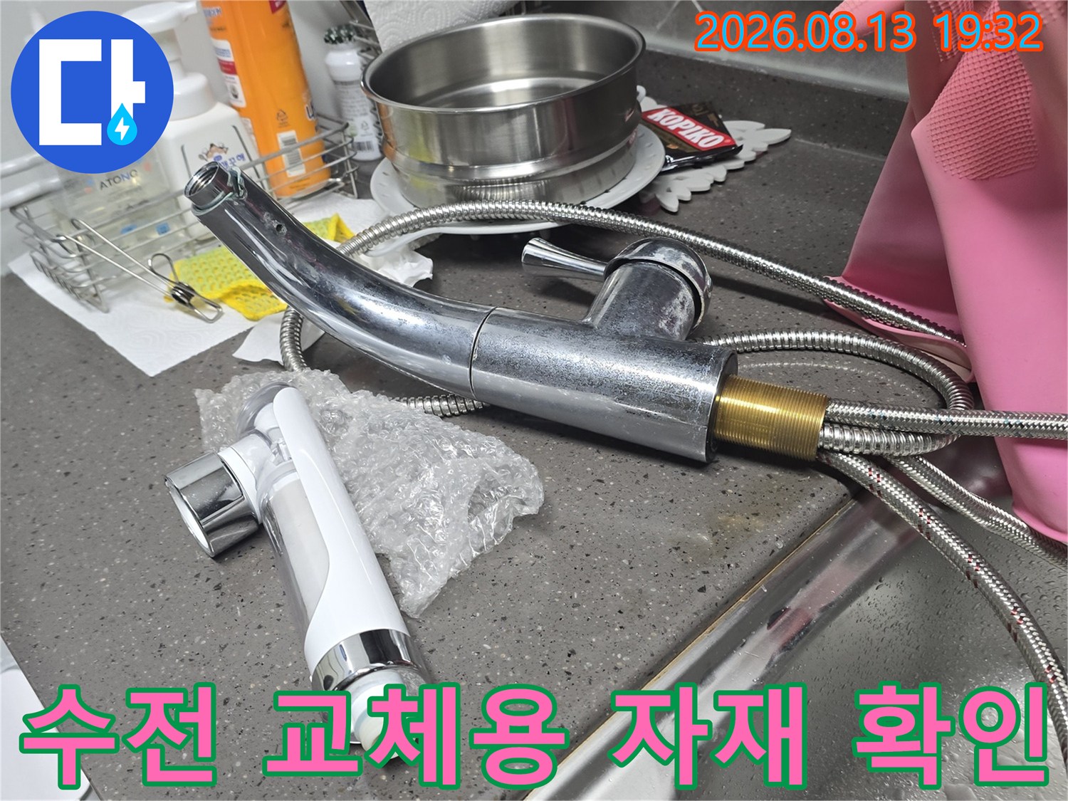 새로 설치할 싱크대 수전 헤드와 금속 급수 호스의 근접 촬영입니다.