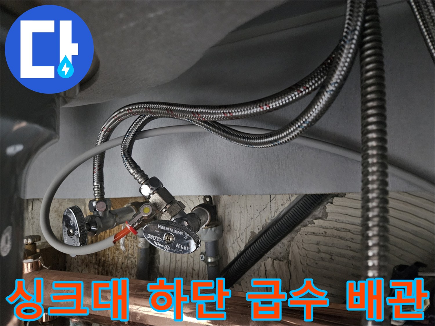 싱크대 아래 설치된 은색 꼬임 호스와 물 공급용 급수 밸브 모습