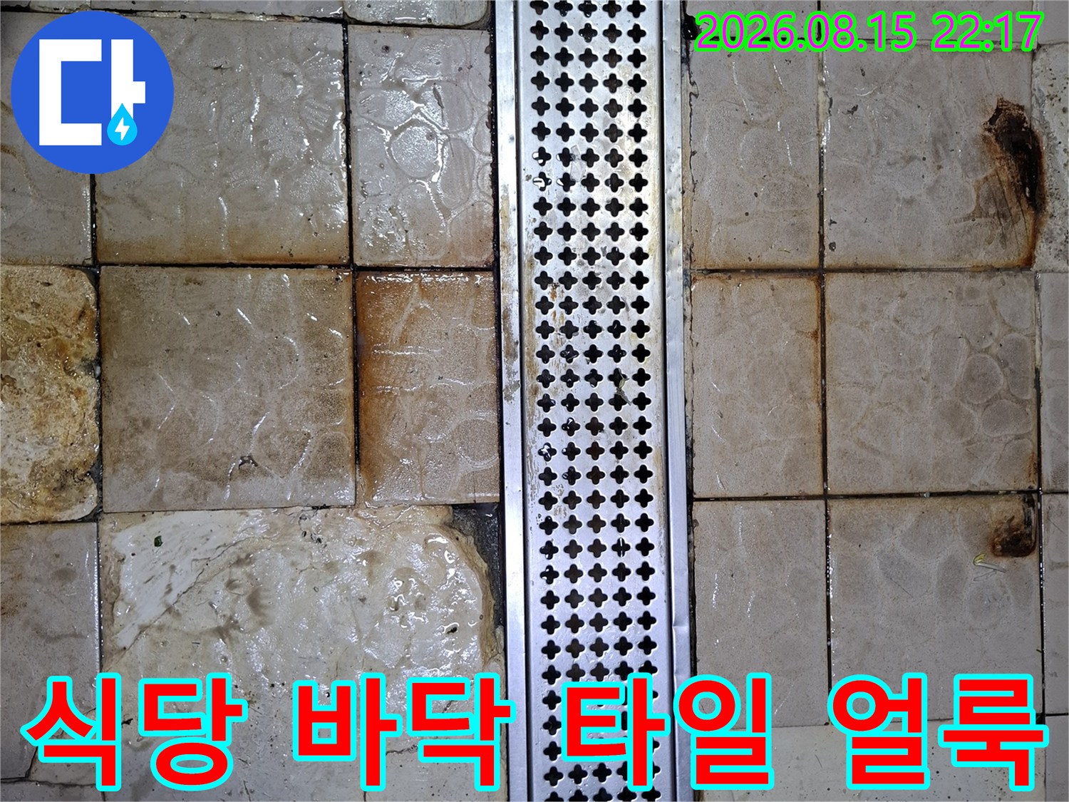 스테인리스 배수구 주변에 발생한 갈색 누수 흔적과 타일 오염