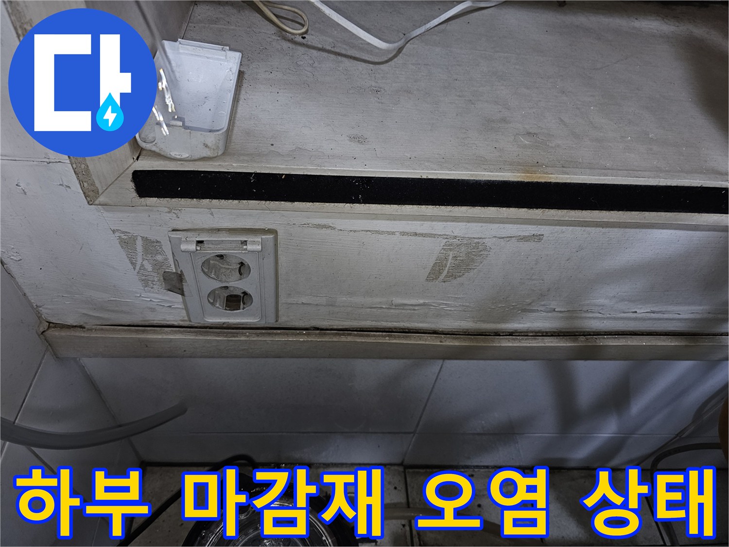 배관 하부 마감재와 벽면 콘센트 주변의 물샘 흔적을 촬영한 사진입니다.
