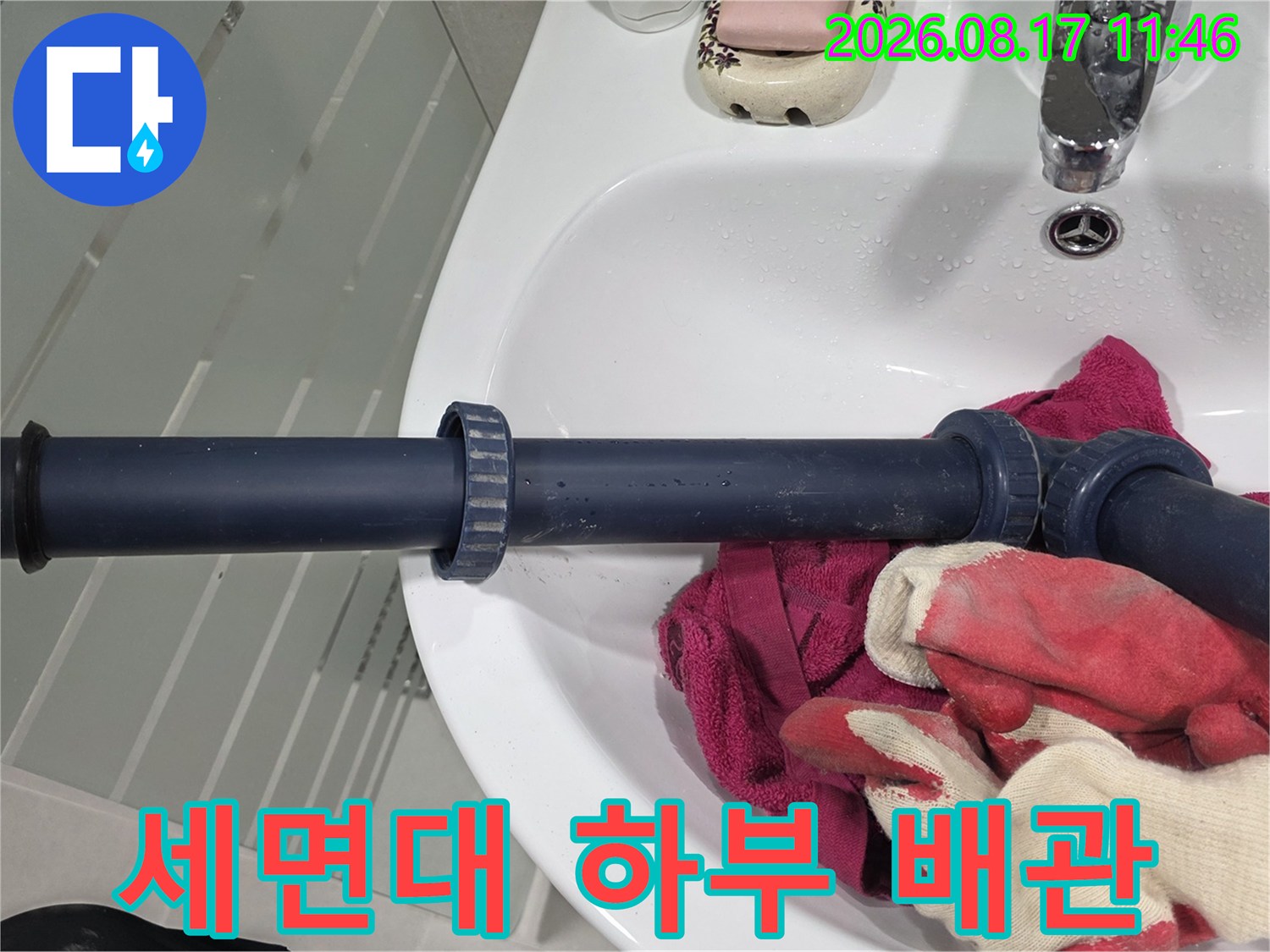 세면대 아래쪽 짙은 색 배수 관로와 연결 부위 근접 사진