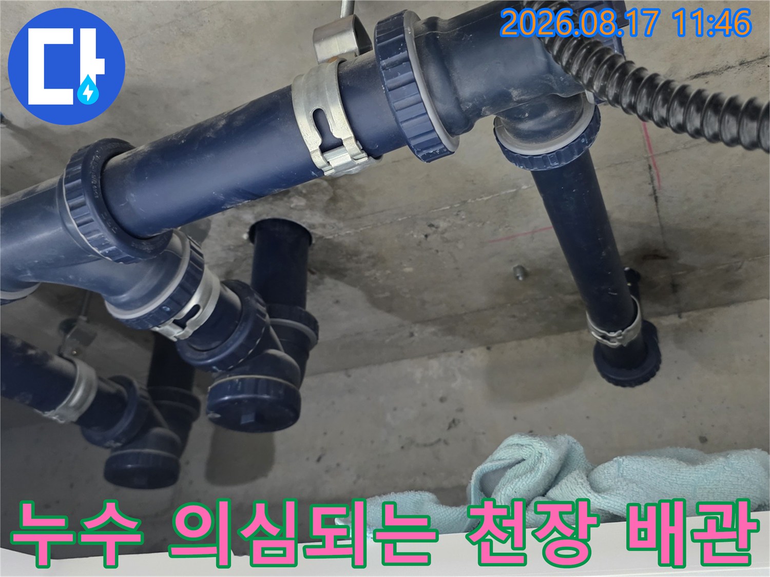 습기가 찬 천장 슬라브와 연결된 파란색 배수 배관의 근접 촬영