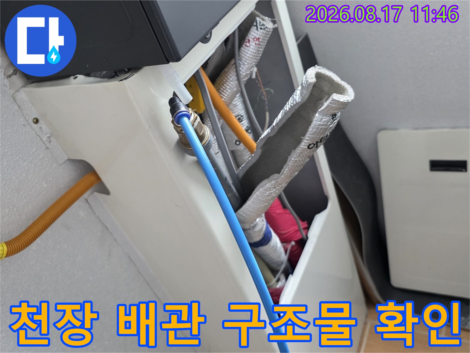 천장 내부의 은박 보온재 처리된 배관과 파란색 호스 연결부