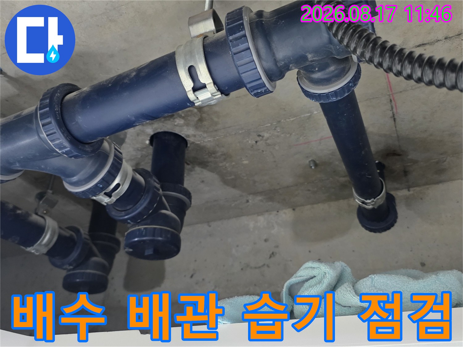 파란색 배관과 천장 슬라브 사이의 물기가 밴 상태를 보여줍니다.