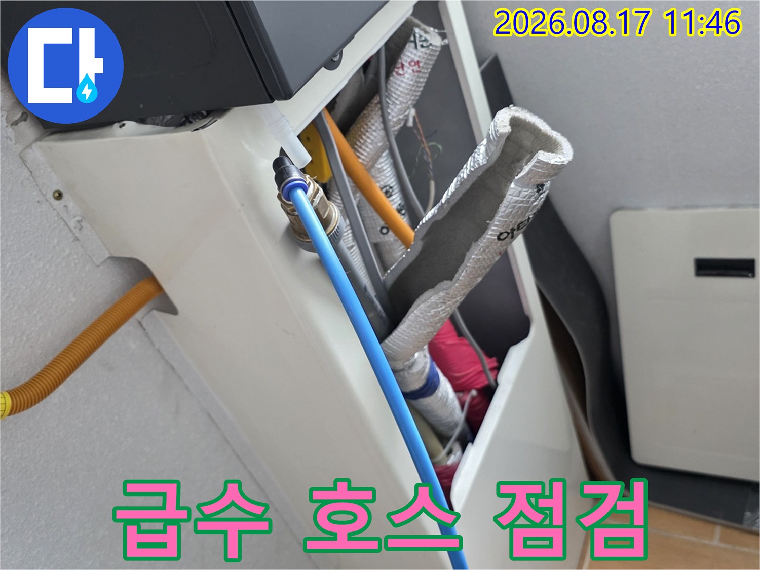 파란색 호스와 은박 보온재가 씌워진 배관의 연결 부위 근접 사진