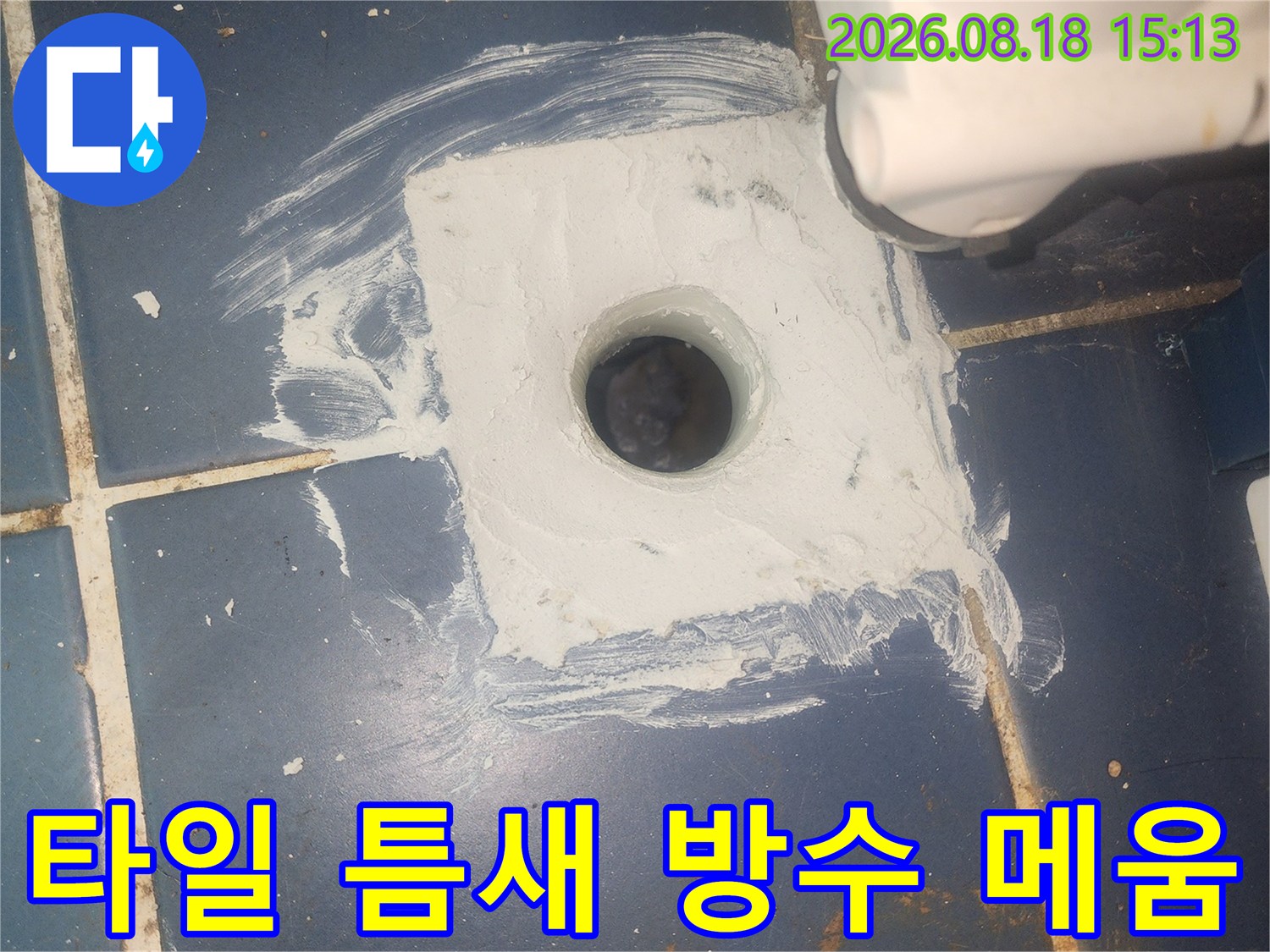 파란 타일 배관 구멍 주변에 하얀 백시멘트를 덧칠하여 보수한 사진입니다.