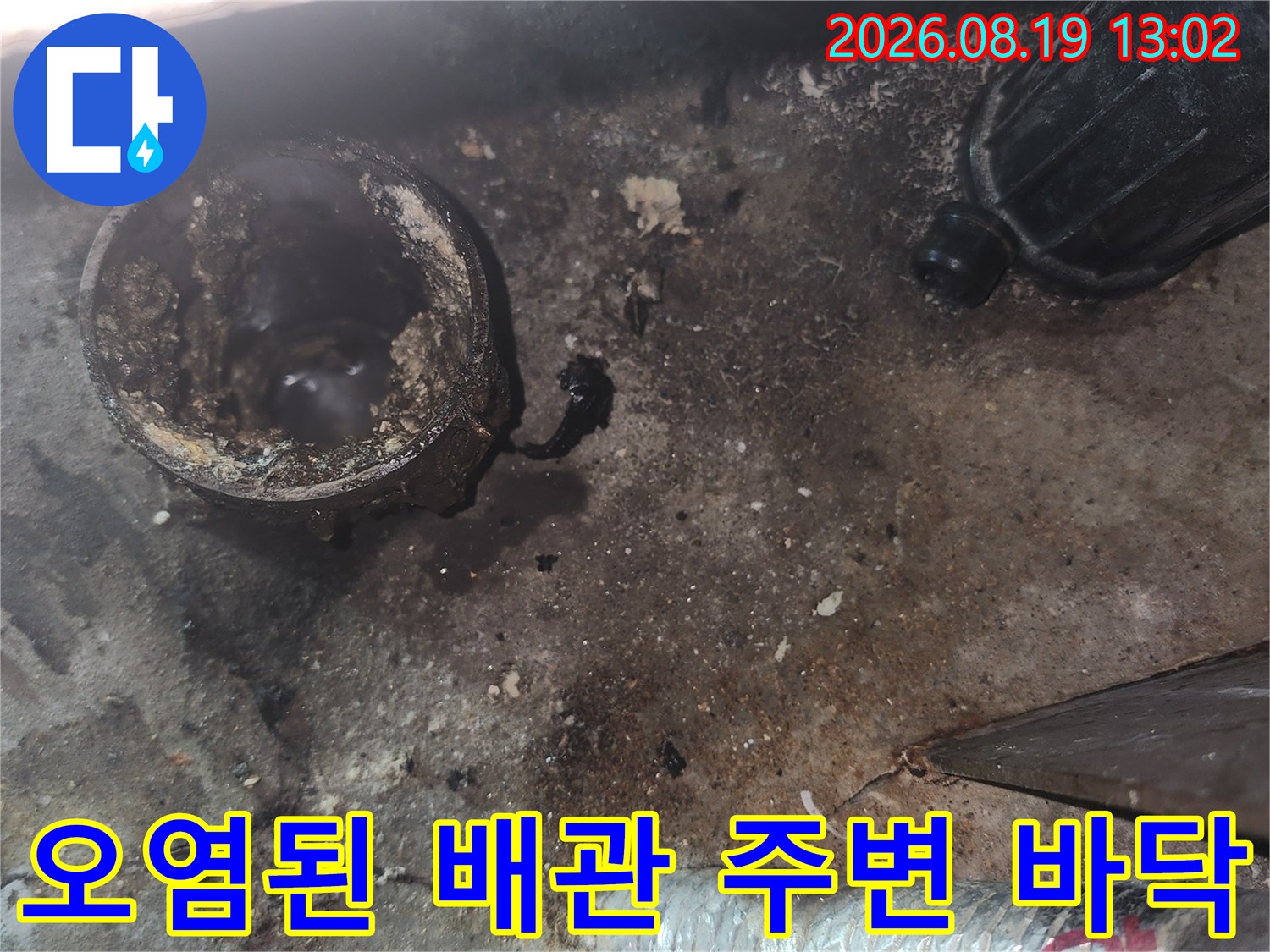 배수관 주변의 물 얼룩과 오염된 바닥 상태입니다.