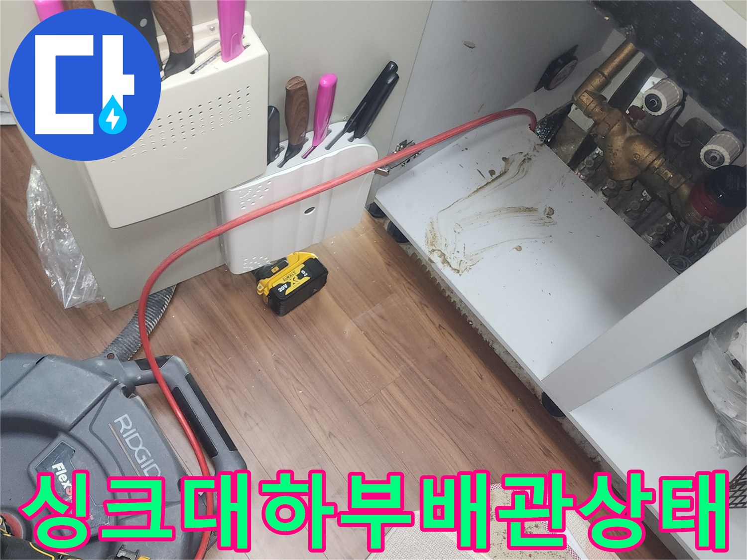 싱크대 밑 배관 주변의 물기 흔적과 장비 세팅