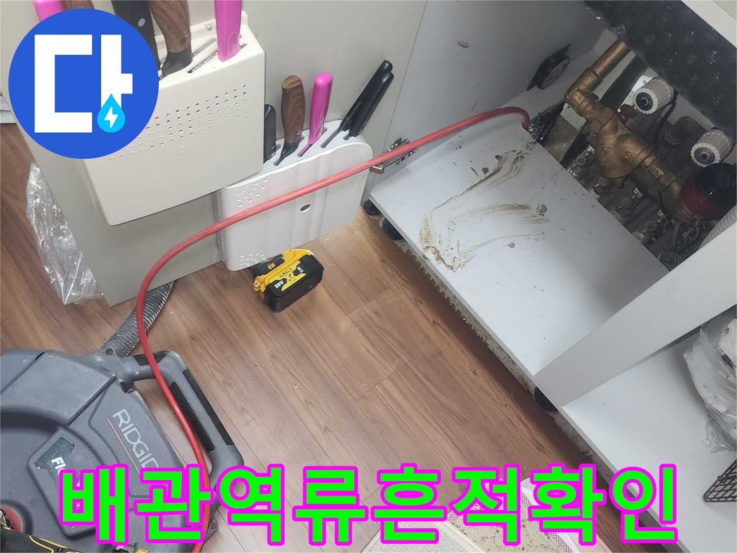 싱크대 하부 배관 주변의 젖은 흔적과 장비