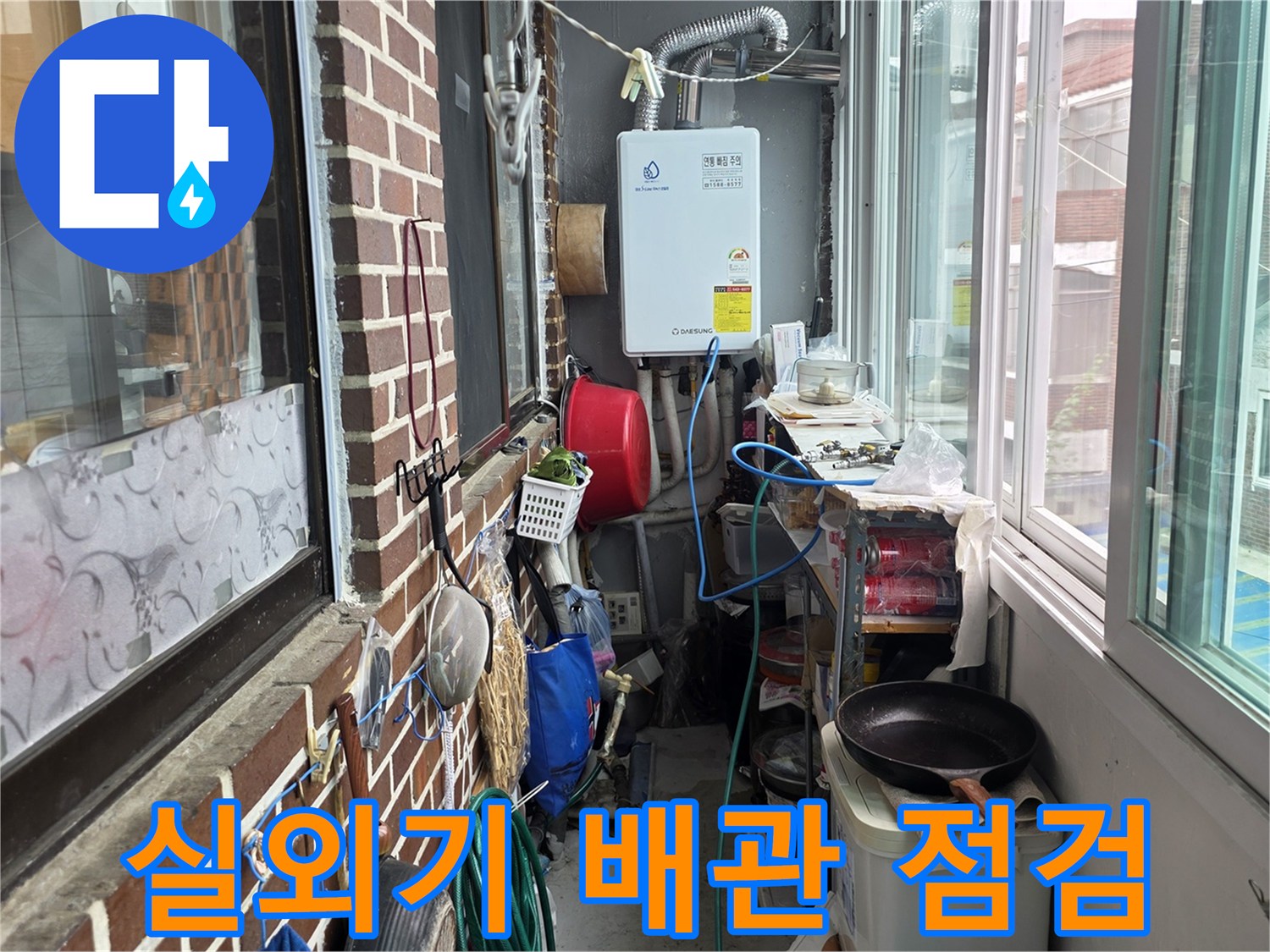 벽돌 외벽에 설치된 실외기와 그 주변으로 지나가는 배관들의 모습입니다.