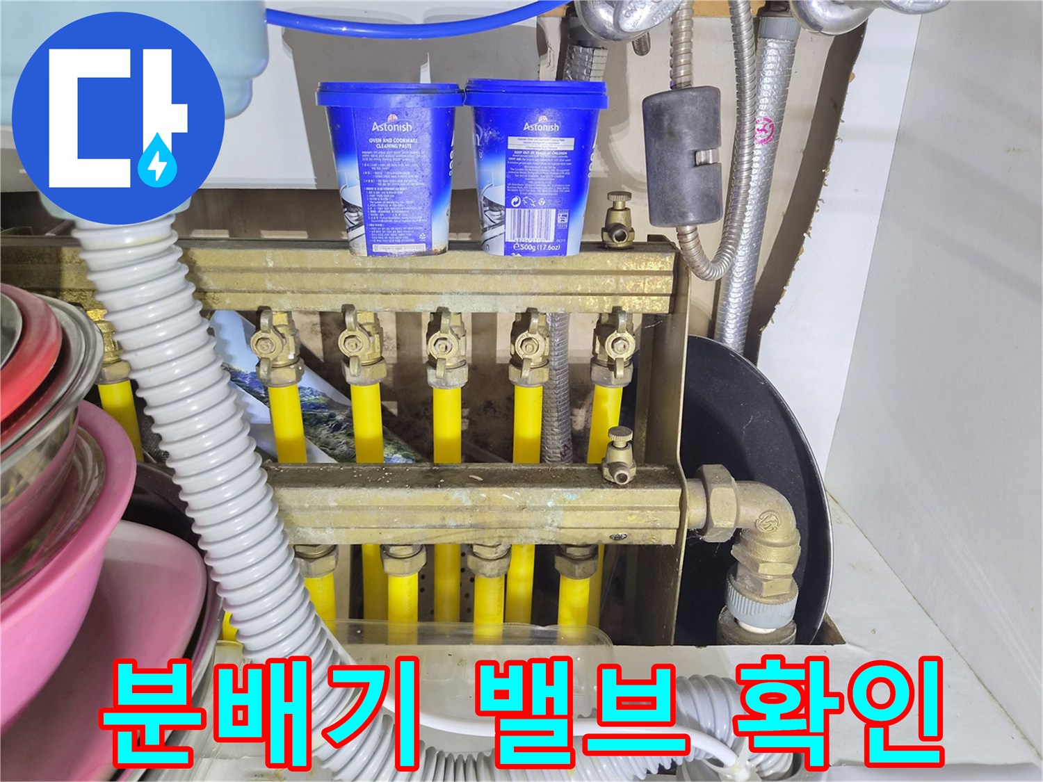 노란색 배관과 금속 분배기 밸브가 연결된 모습