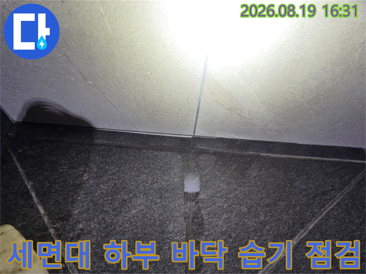 세면대 아래쪽-바닥 타일 틈새에 물기가 배어 나온 현장 모습입니다.