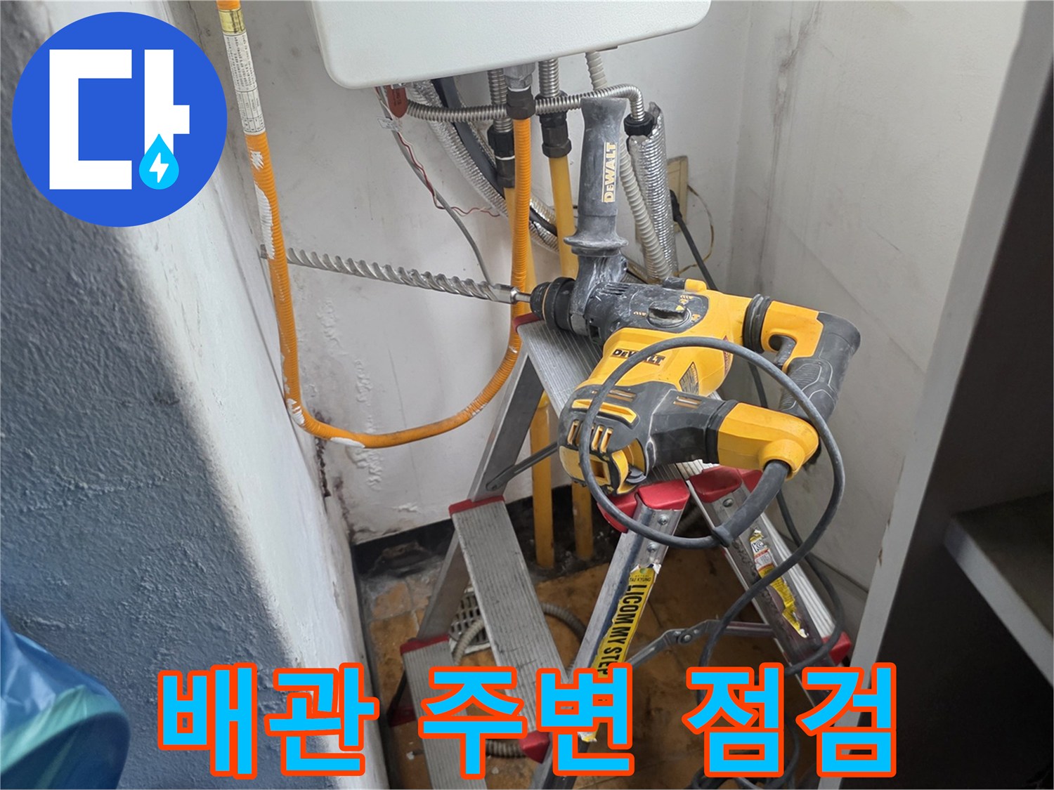 천장 배관 틈새를 확인하기 위해 사다리 위에 배치된 전동 드릴과 장비