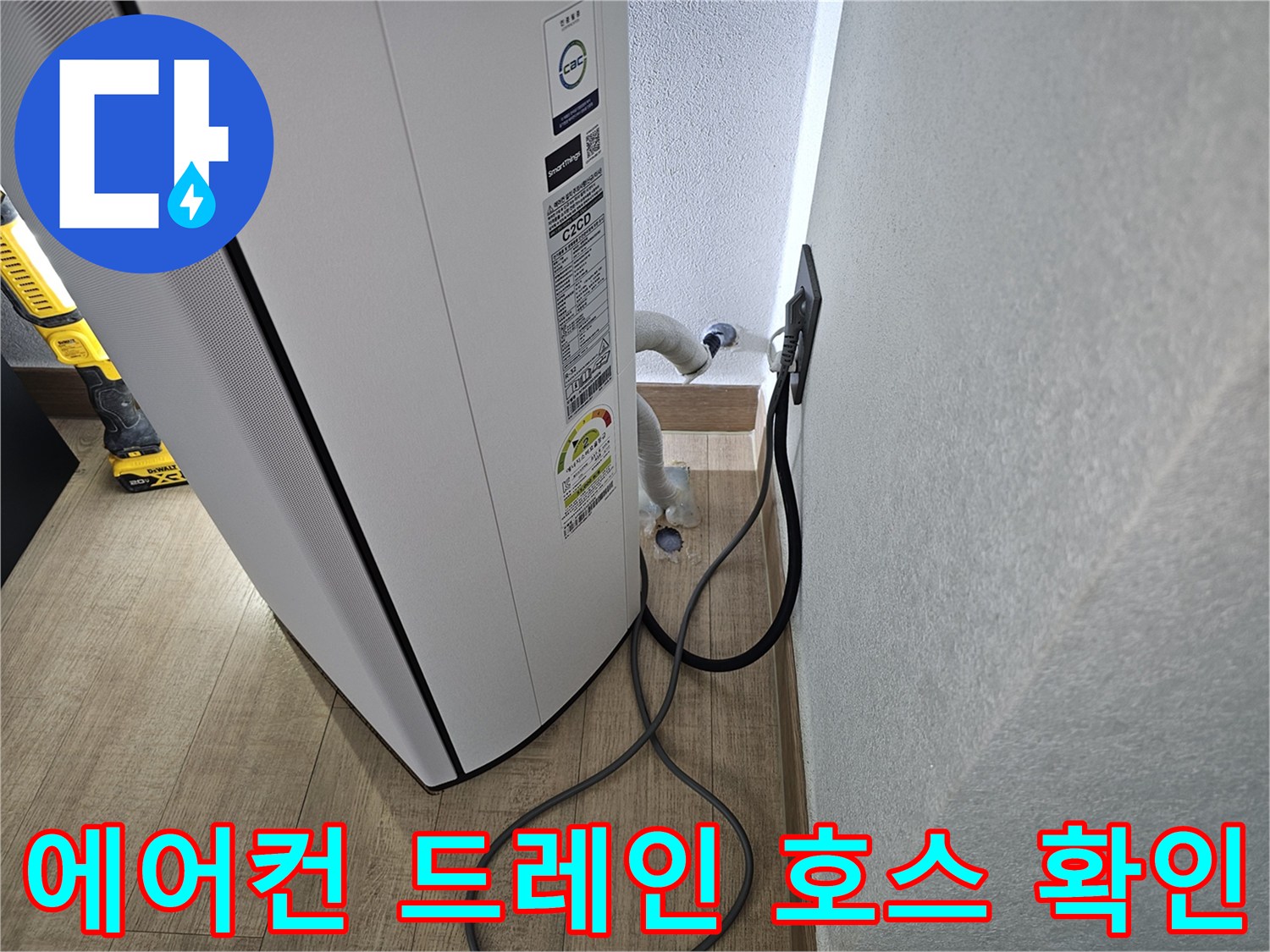 에어컨 밑으로 연결된 하얀색 배수 호스의 위치를 나타냅니다.