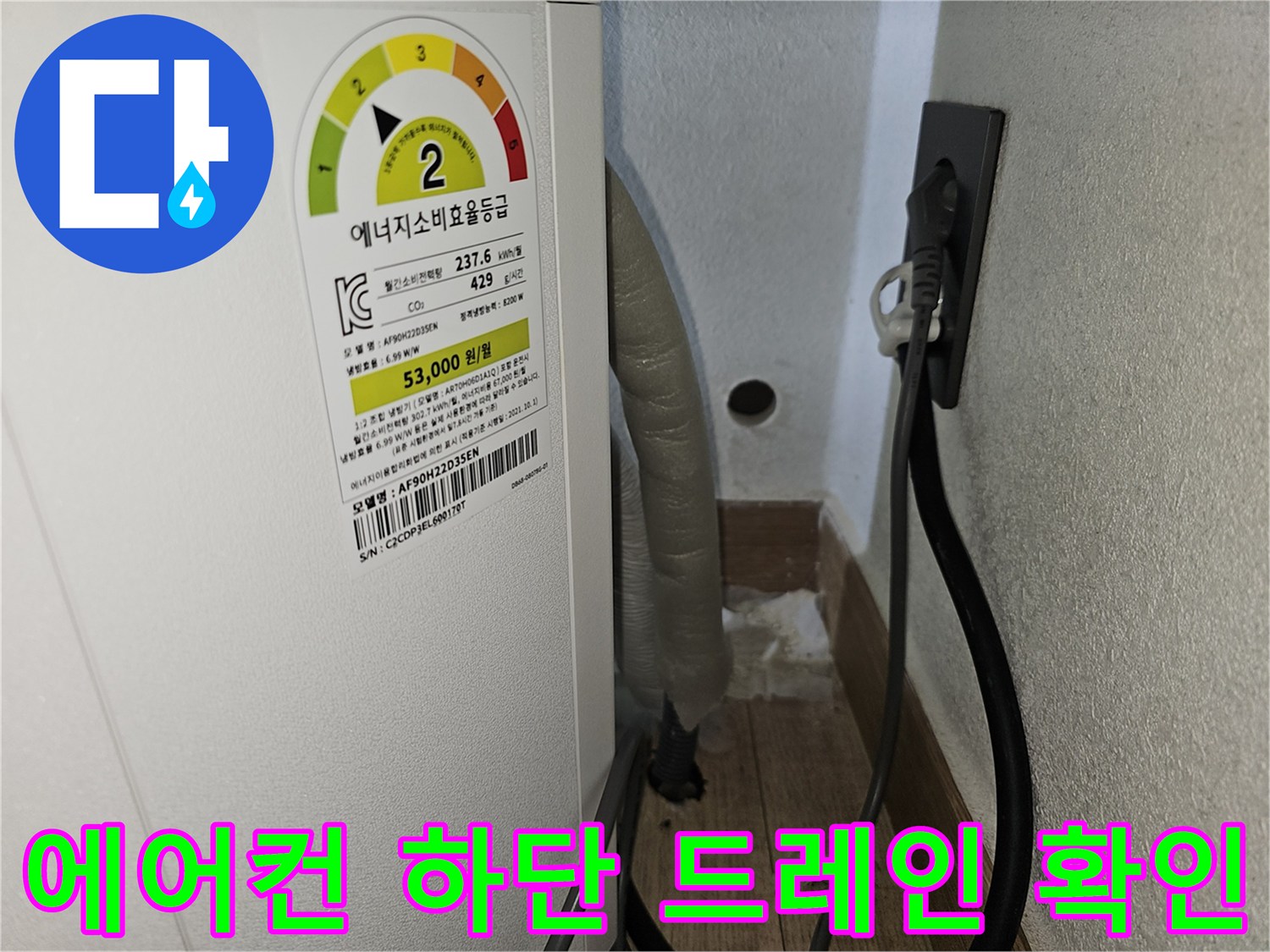 에어컨 본체 하단부의 배수 호스 연결 구간