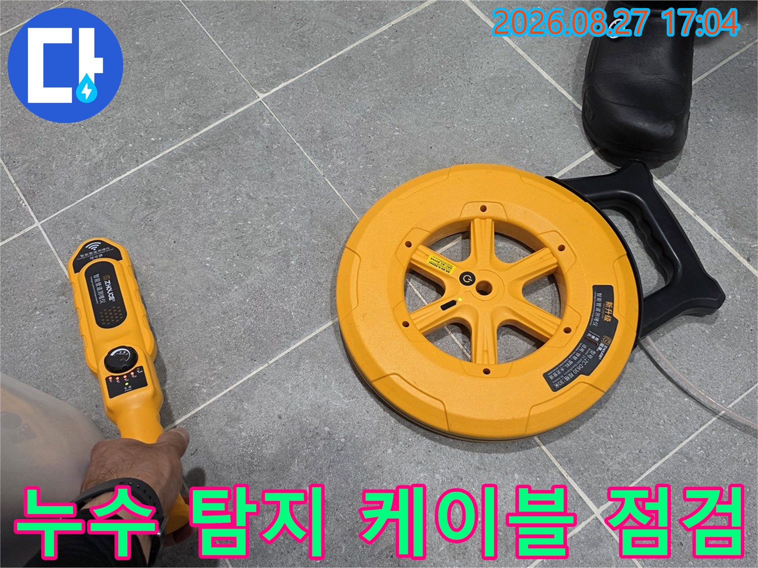 회색 타일 위로-노란색 탐지 장비를 사용하여 누수 지점을 정밀하게 추적하고 있습니다.
