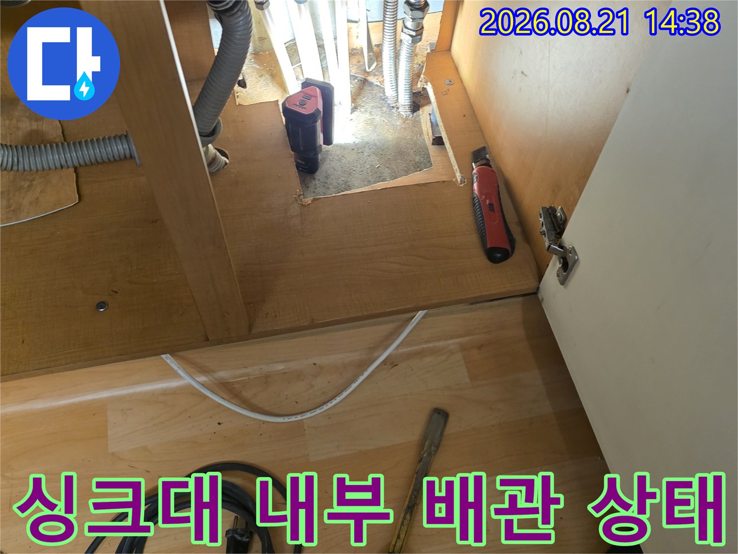 싱크대 하부장 안쪽의 복잡한 주름관과 연결 부위 모습