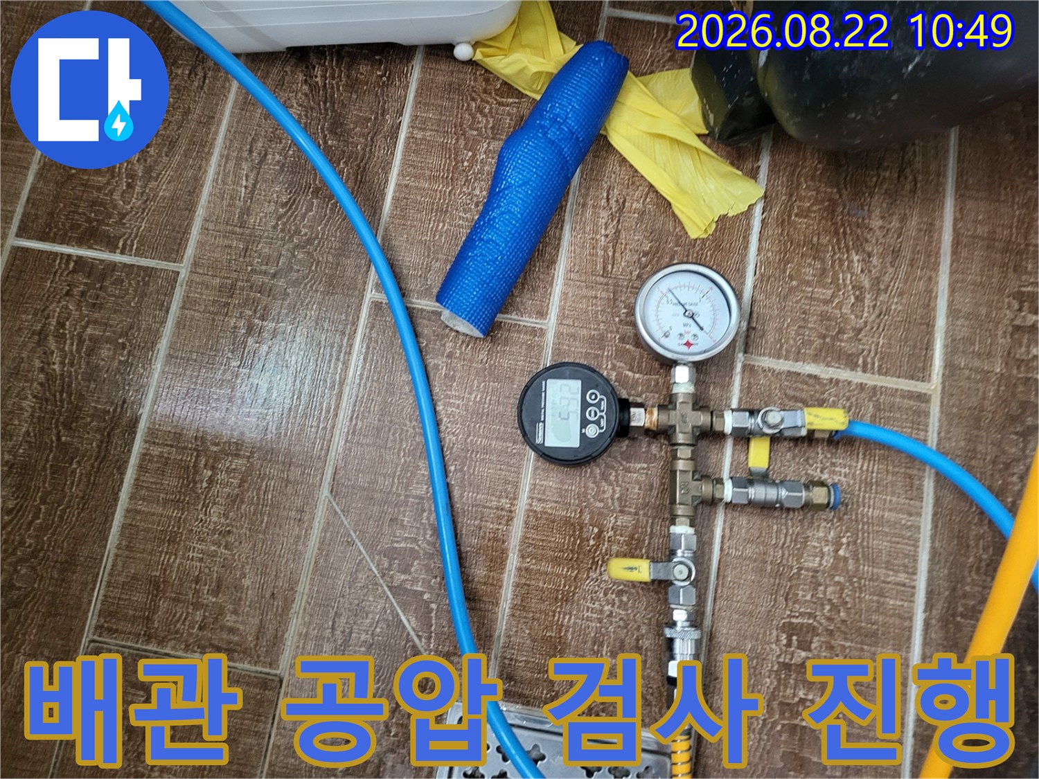 안양동 누수 현장의 배관 공압 테스트를 위한 압력계와 연결 호스 모습