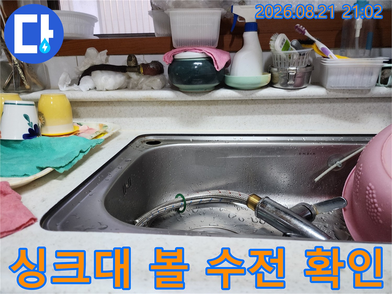 물기가 있는 싱크볼과 수전 헤드를 찍은 현장 사진입니다.
