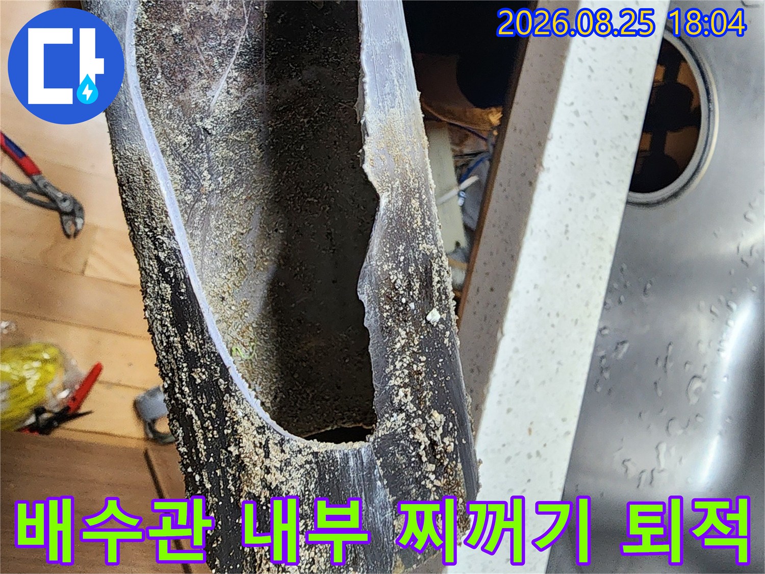 싱크대 배수관 내부에 쌓인 오염물질과 찌꺼기 상태를 보여주는 사진입니다.