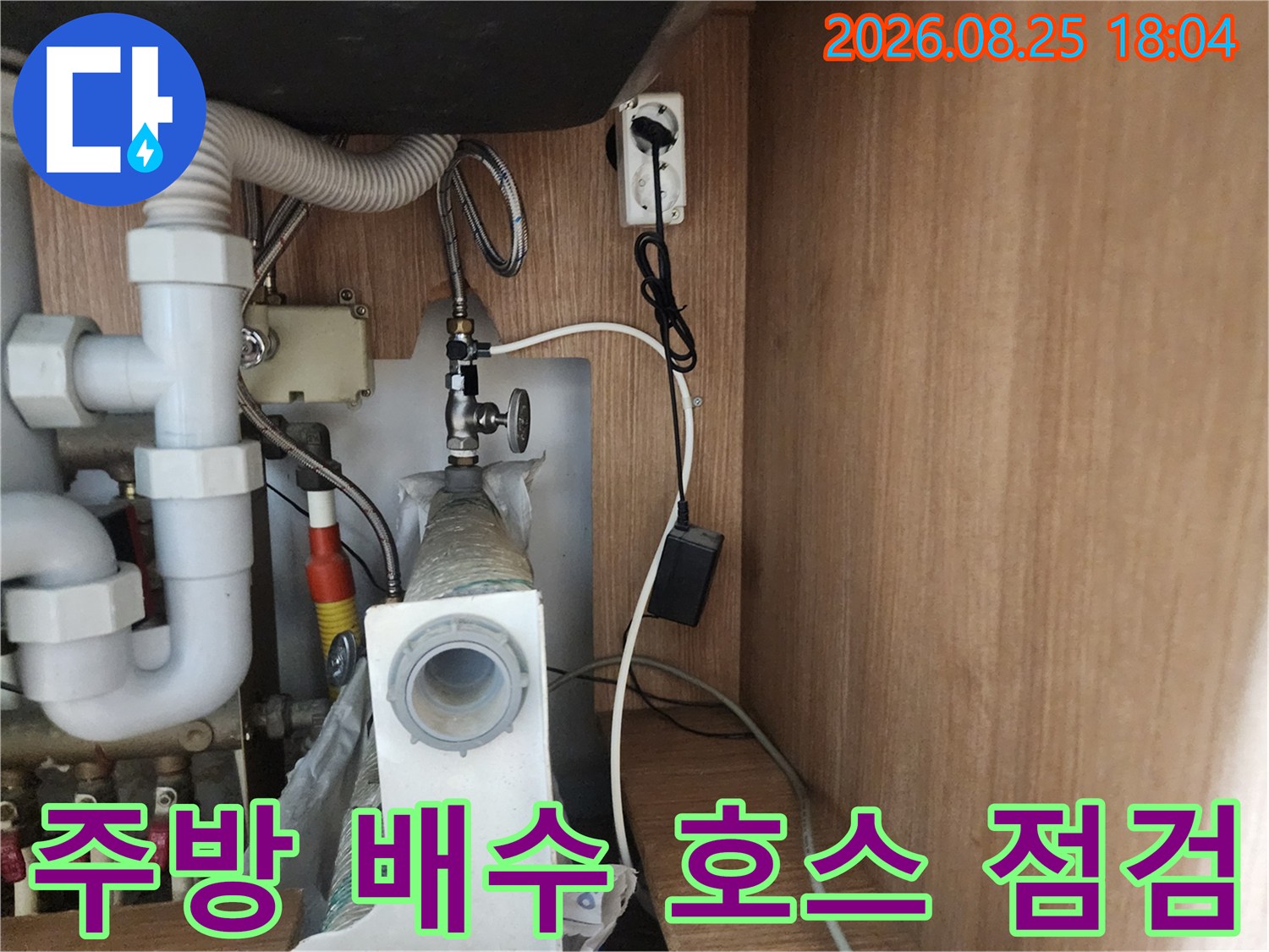 싱크대 하부의 굴곡진 배수 호스와 수전 연결 부위 상세 이미지