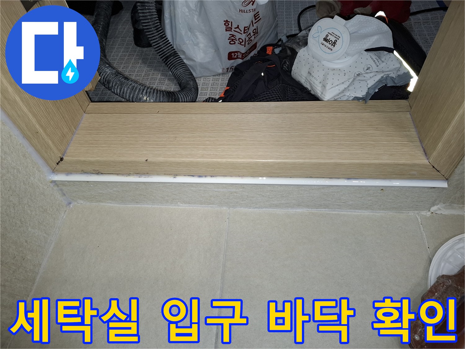 세탁실 문턱 부근의-타일 마감 상태와 장비 배치 현황