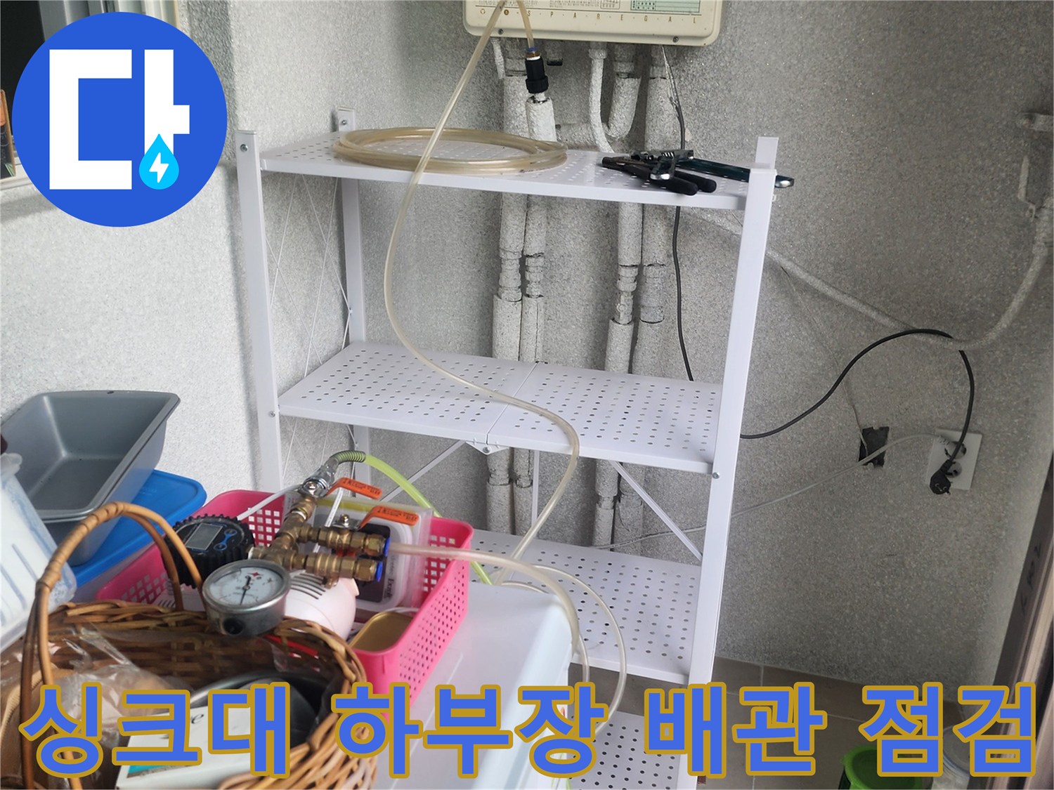 용인 기흥구 아파트 싱크대 아래쪽 복잡한 배관 라인과 장비 배치 모습