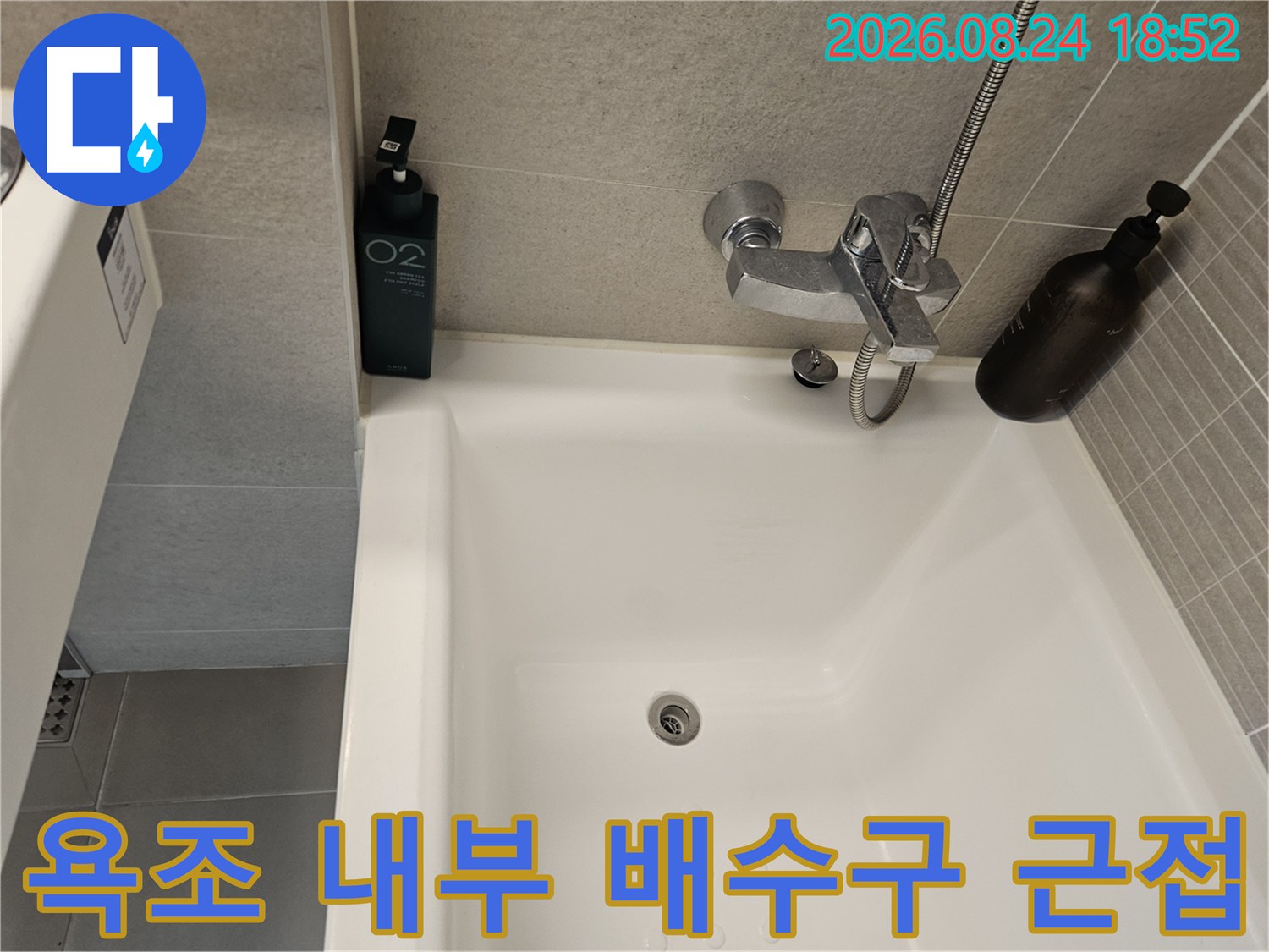 욕조의 배수구와 벽면에 설치된 수전 부속품 사진입니다.